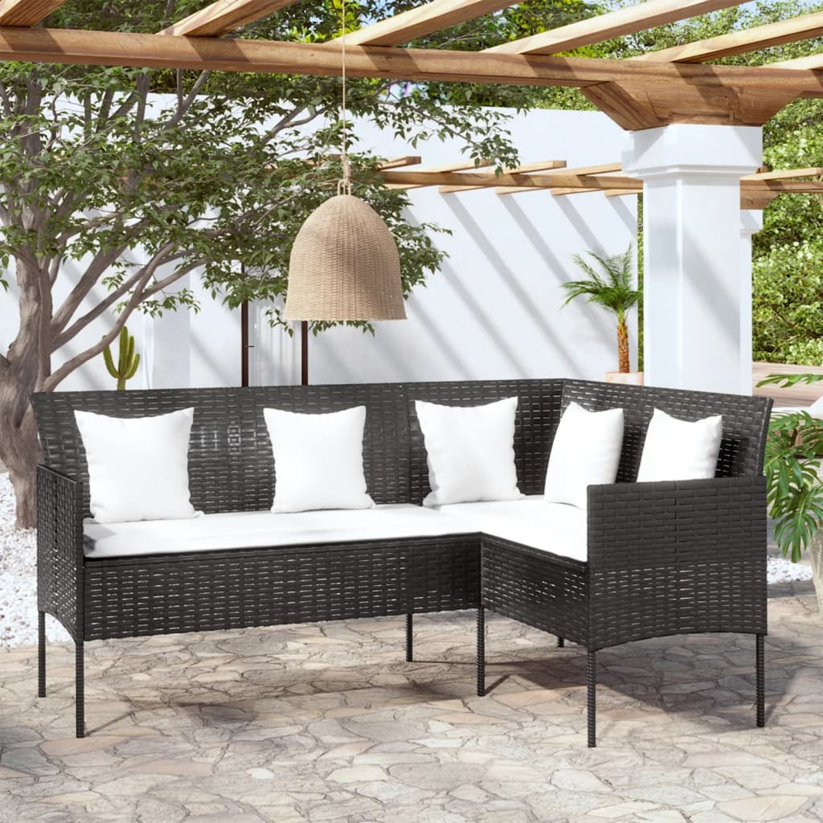 Schwarzes Ecksofa aus Rattan mit weißen Kissen.