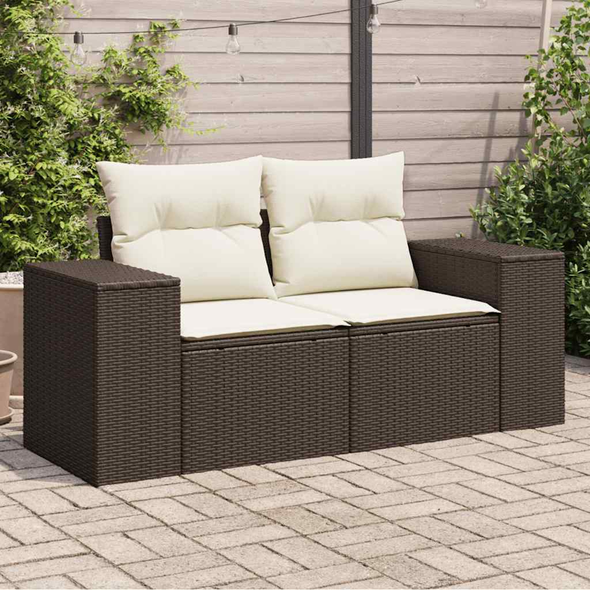 Divano marrone a due posti per esterni con cuscini color crema. Patio pavimentato.