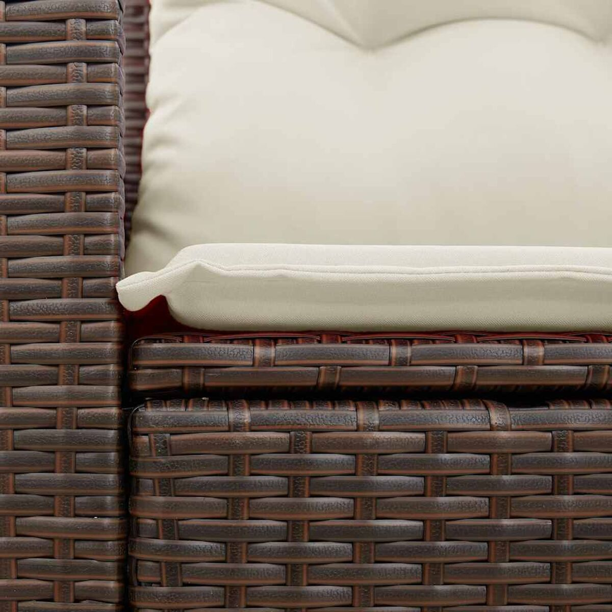 Primo piano di divano in rattan marrone. Cuscino bianco sopra. Trama intrecciata visibile.