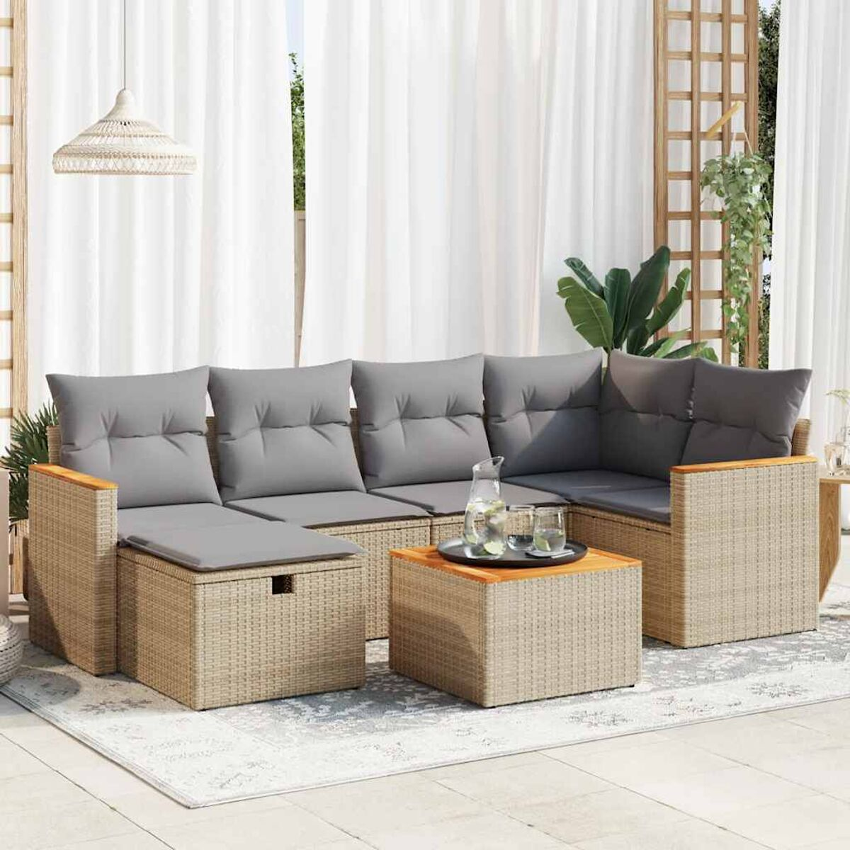 Beiges Outdoor-Ecksofa aus Korbgeflecht mit grauen Kissen auf einer Terrasse. Tisch und Vorhänge im Hintergrund.