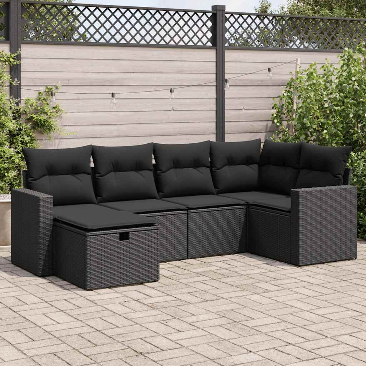 Schwarzes Outdoor-Ecksofa mit Kissen auf einer Terrasse, umgeben von einem Zaun.