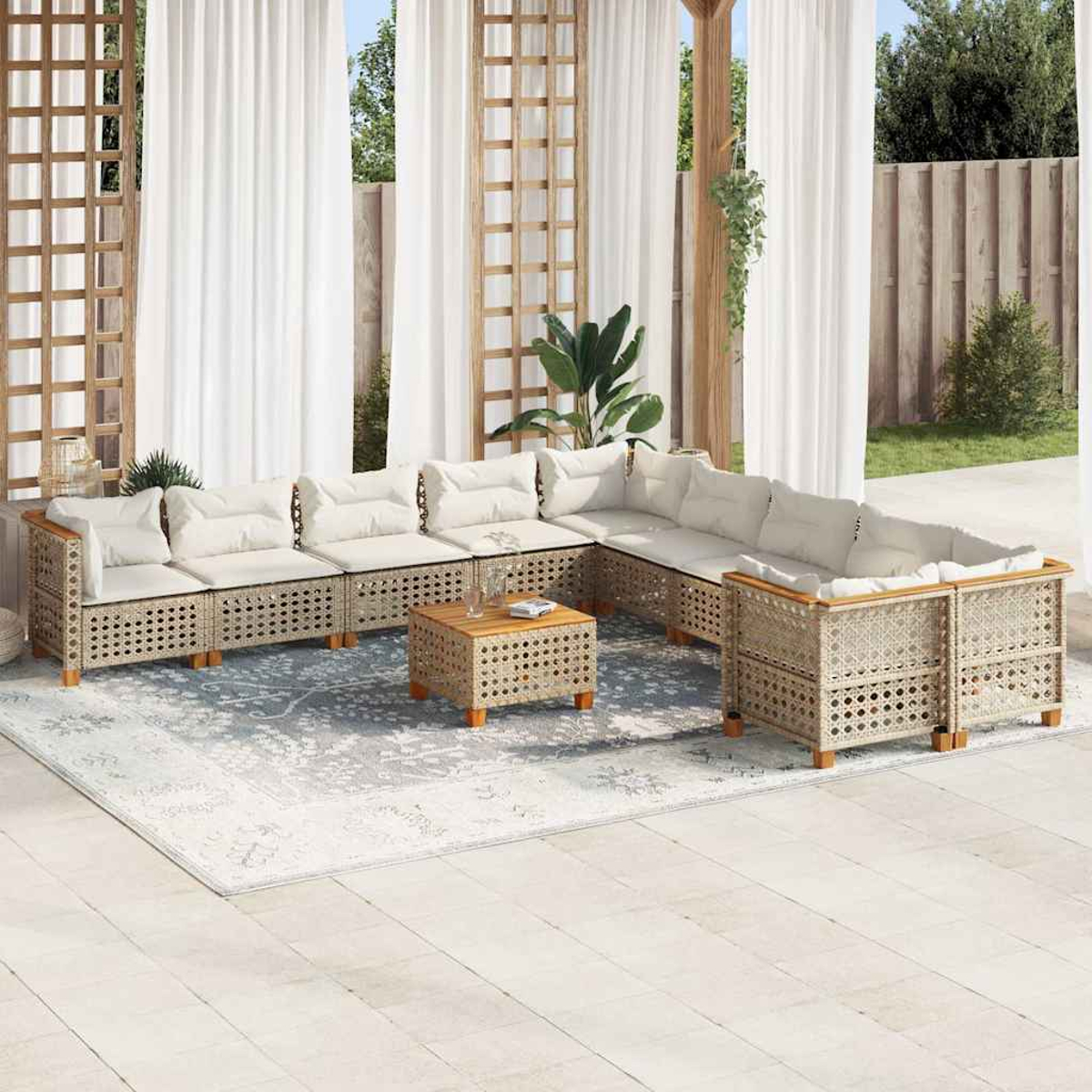 Set lounge all'aperto su un patio. Include un divano componibile e un tavolino, con tende bianche sullo sfondo.