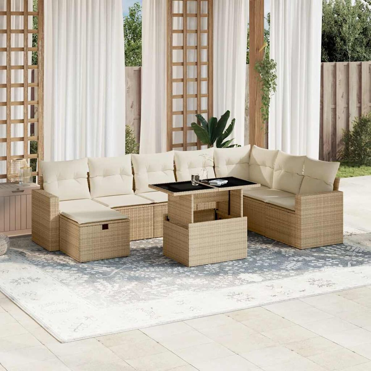 Un set di divani componibili con un tavolo. Il set è in vimini e ha cuscini beige. La scena è all'aperto.