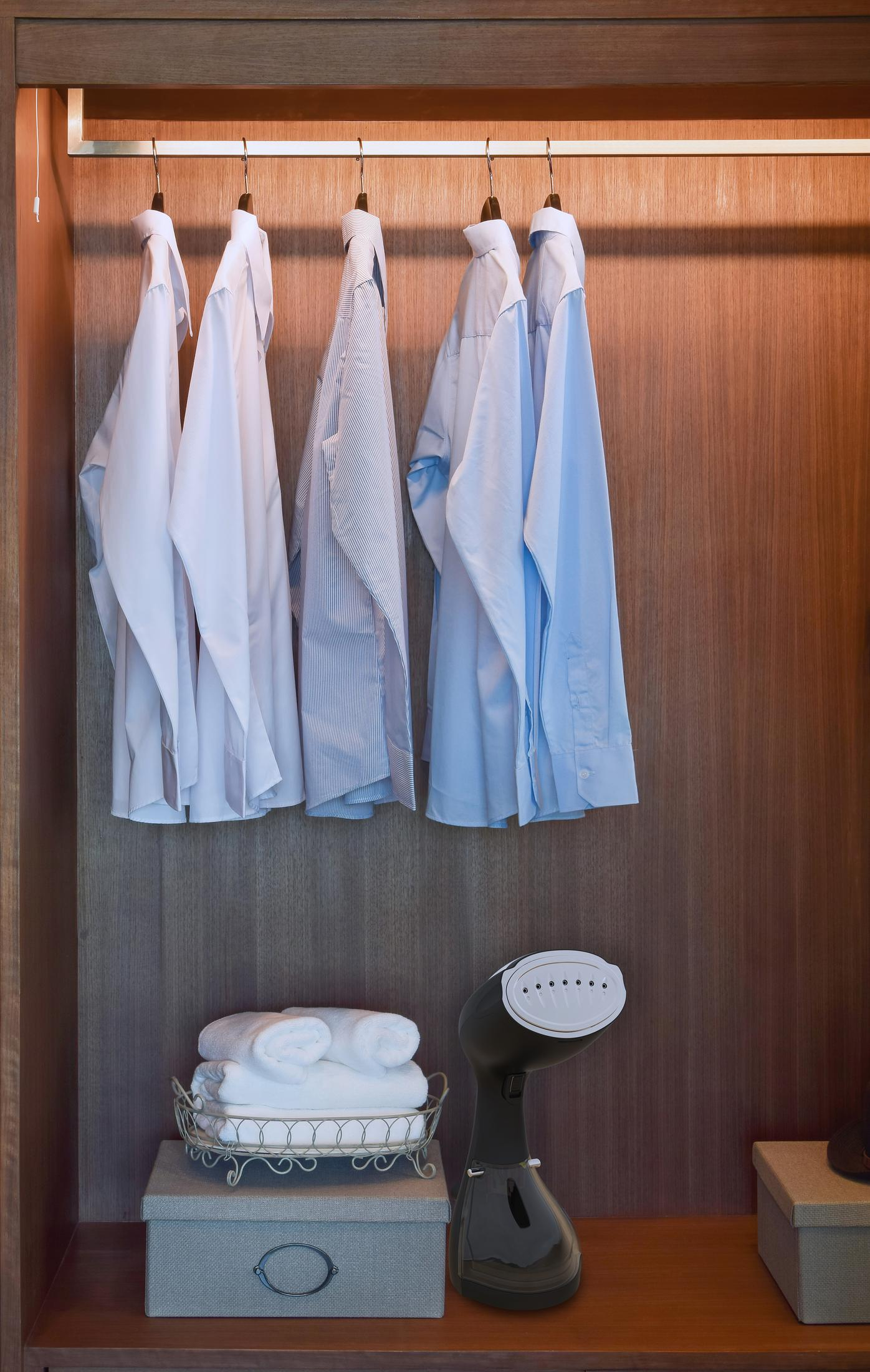 Intérieur d'un placard. Chemises, serviettes et un défroisseur.