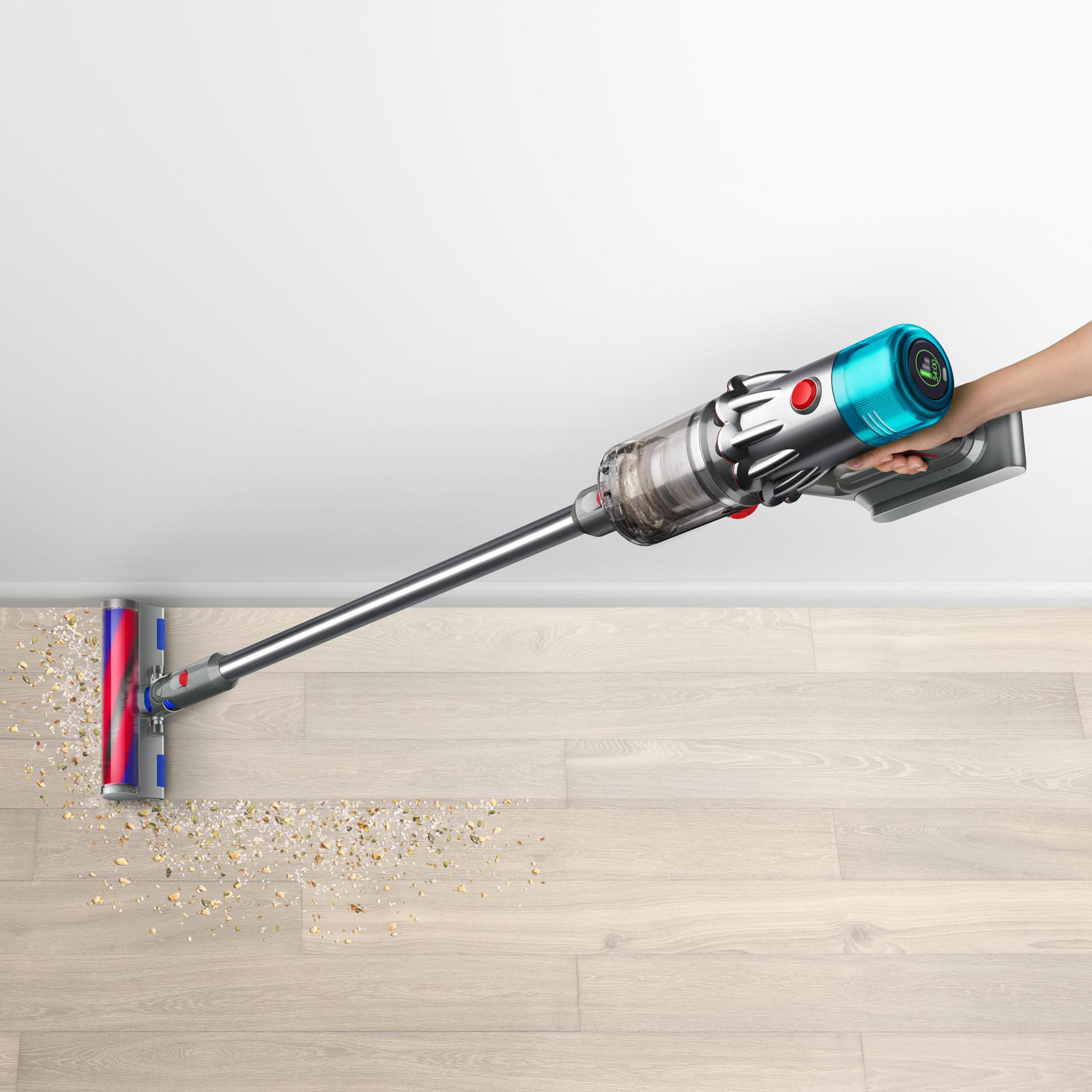 Eine Person benutzt einen kabellosen Staubsauger auf Holzboden.