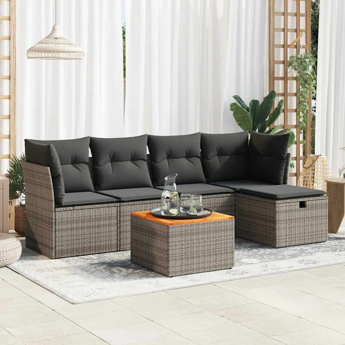 Outdoor-Sofa-Set mit grauen Kissen und einem Tisch. Weiße Vorhänge im Hintergrund.
