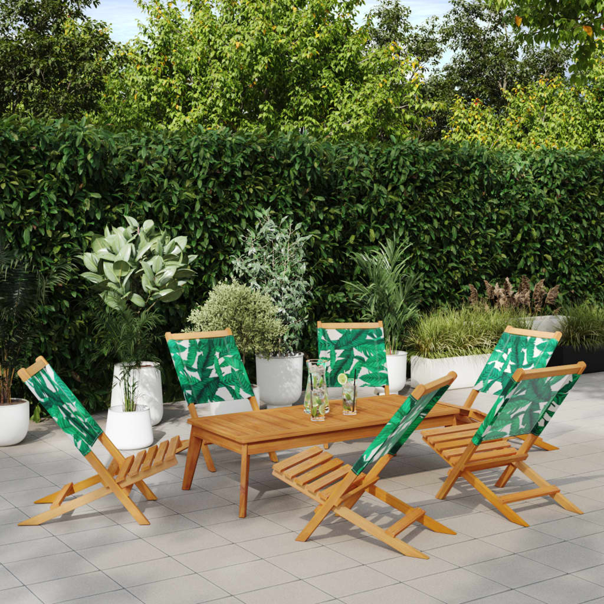 Gartenmöbel-Set aus Holz mit Stühlen mit grünem Blättermuster, Tisch und blauem Sonnensegel im Hintergrund.