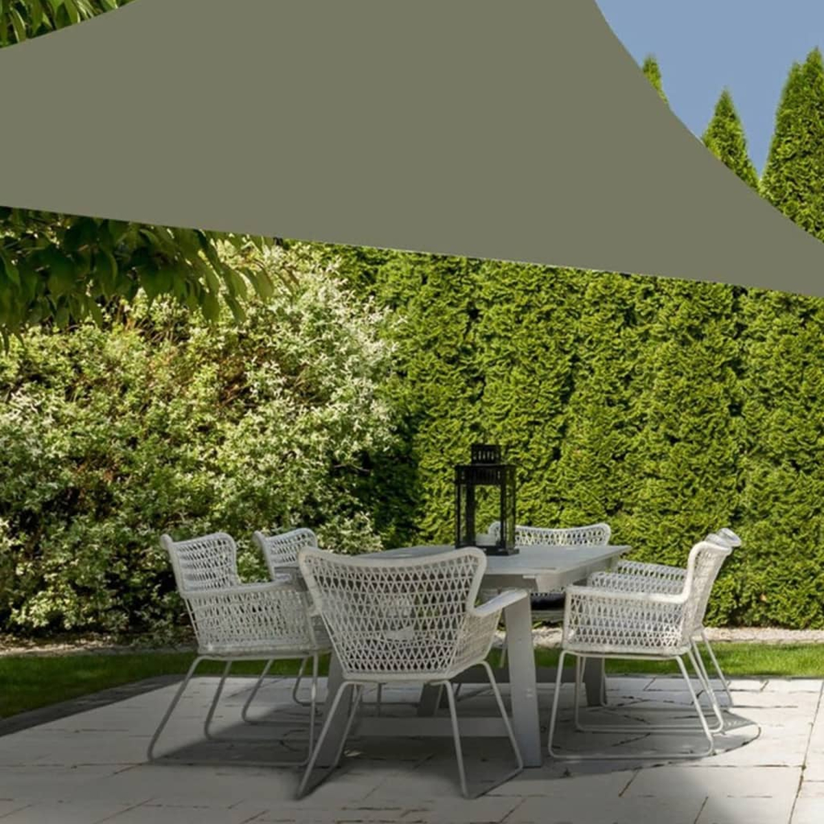 Set per patio all'aperto con sedie bianche attorno a un tavolo bianco. Un'ombra verde copre la parte superiore.