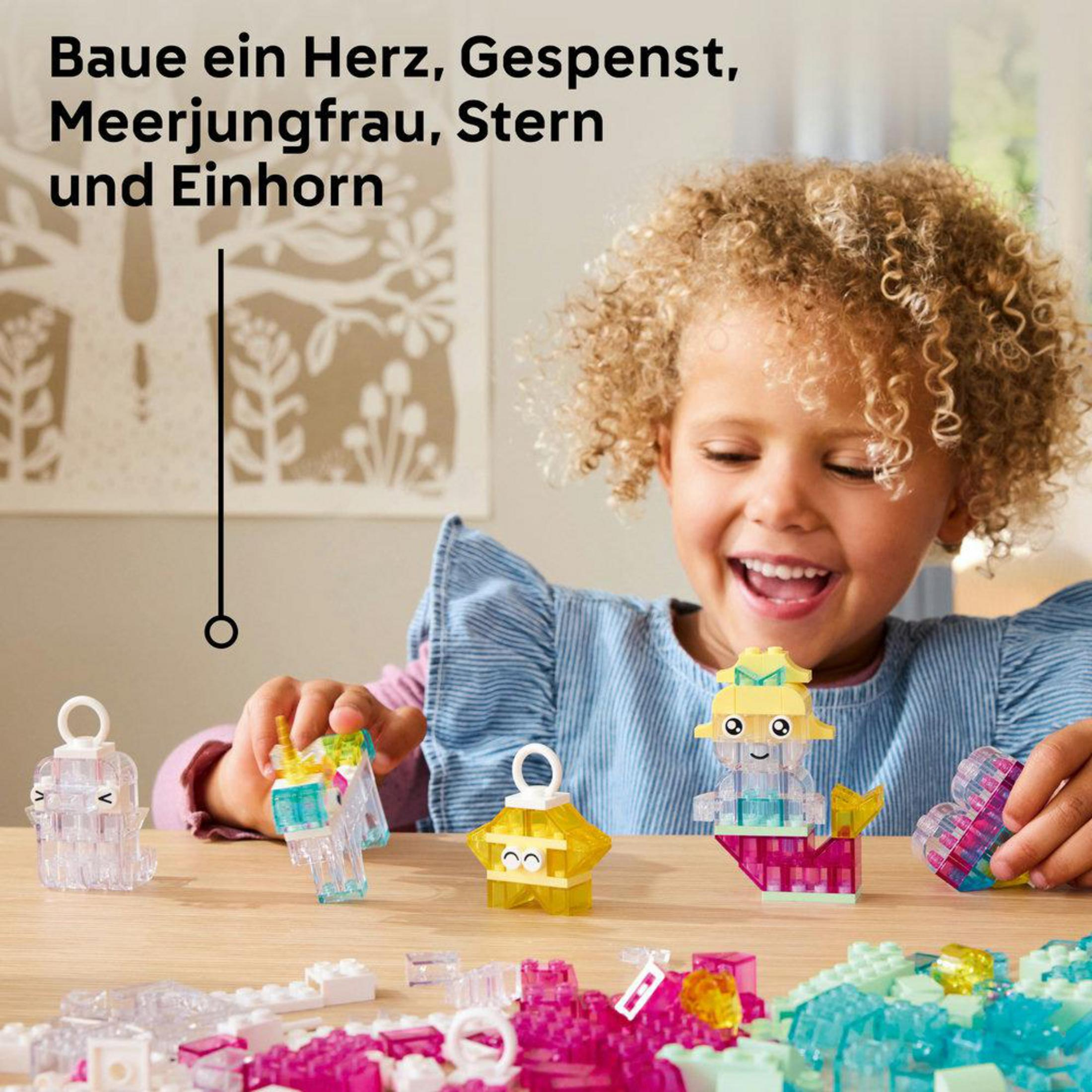 Mała dziewczynka bawi się klockami Lego, budując figurki jednorożca, ducha i syreny.