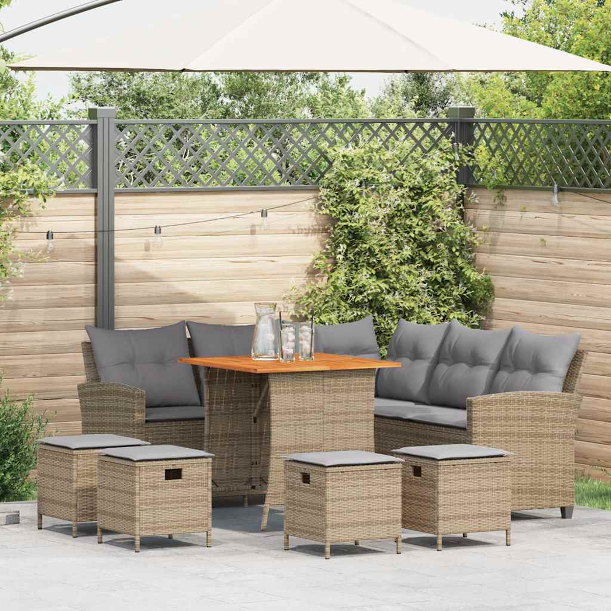Outdoor-Sitzbereich mit Sofa, Stühlen und Hockern, um einen Tisch mit Sonnenschirm angeordnet.