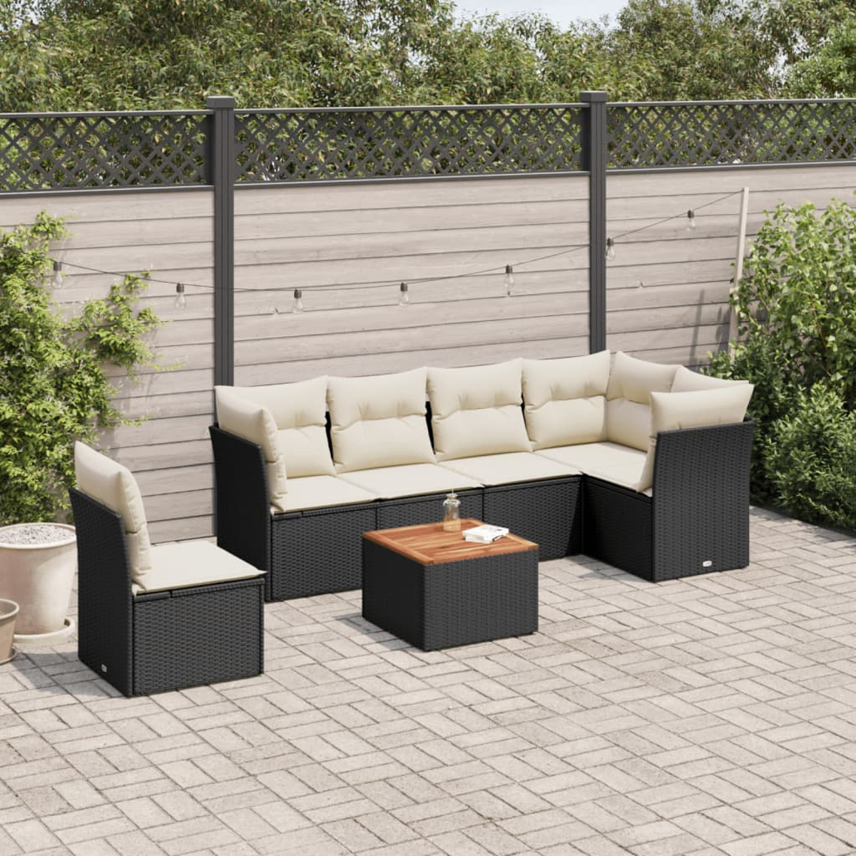 Ein Sitzgruppe für den Außenbereich mit Tisch und Stuhl. Schwarzes Rattan mit hellem Kissen.