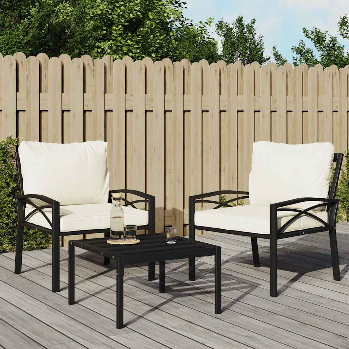Terrassenset mit schwarzem Metallrahmen und weißen Kissen auf Holzterrasse.