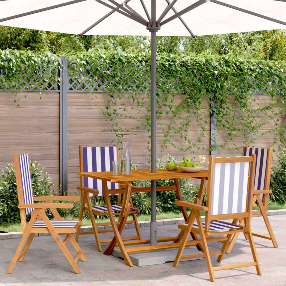 Set da pranzo per esterni con tavolo, sedie e ombrellone bianco, in un giardino.