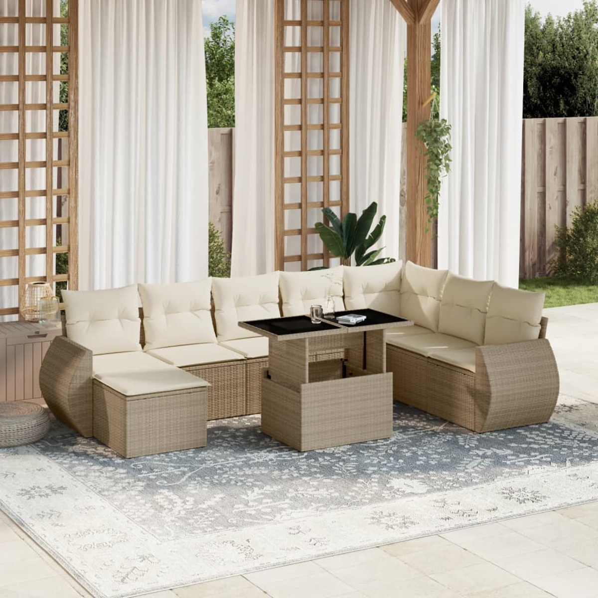Set divano in rattan da esterno con cuscini beige e tavolo sollevabile su un tappeto blu.