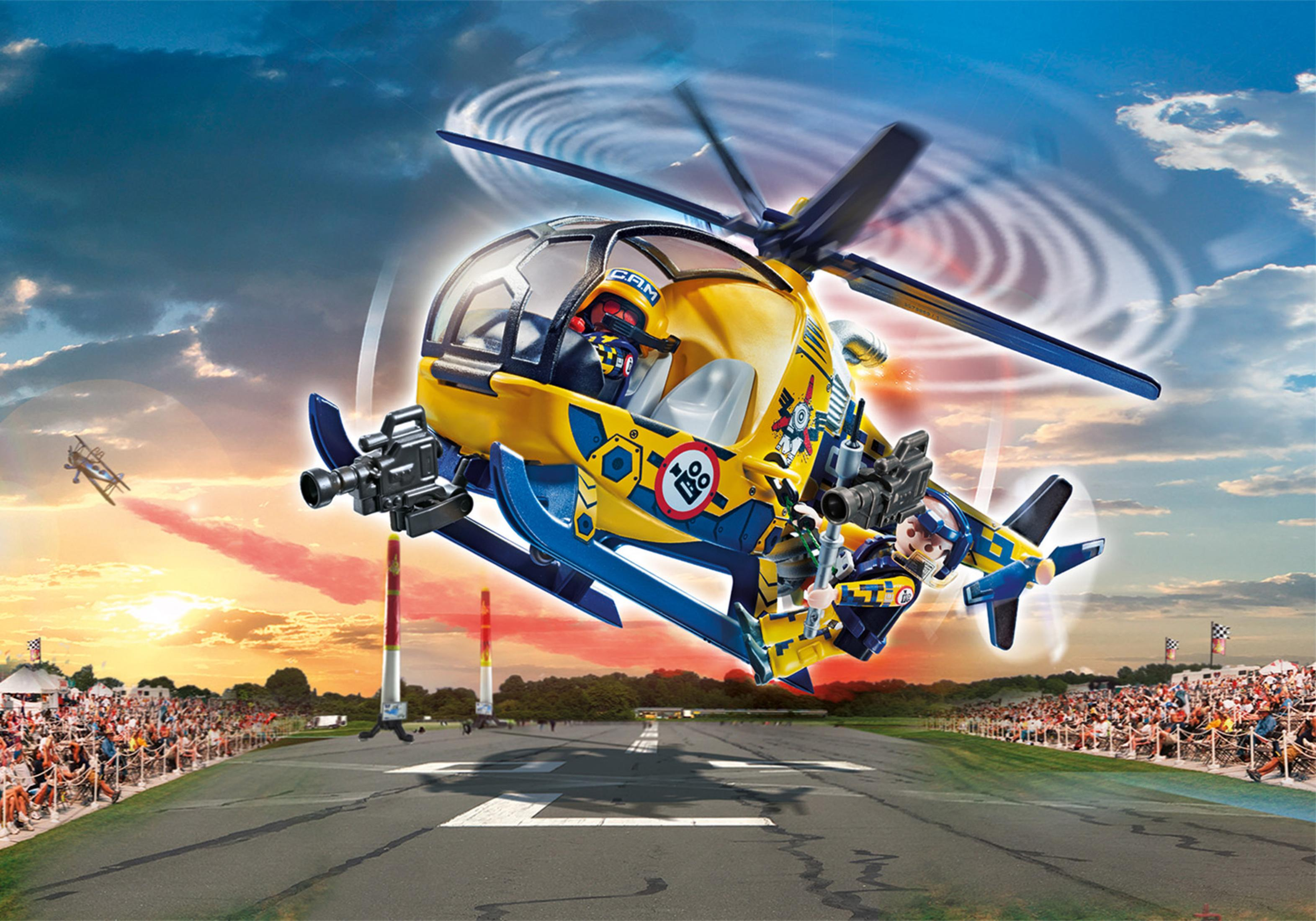 Ein gelber und blauer Spielzeughelikopter im Flug mit Figuren, über einer Rennstrecke.