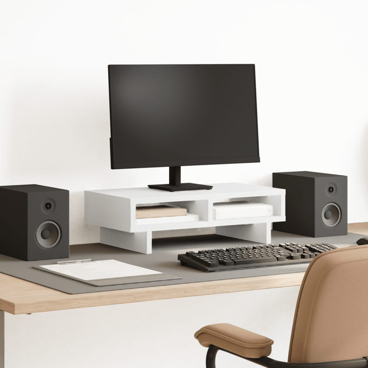 Ein Schreibtisch-Setup mit Monitor, Lautsprechern und Tastatur auf einer Holzoberfläche.