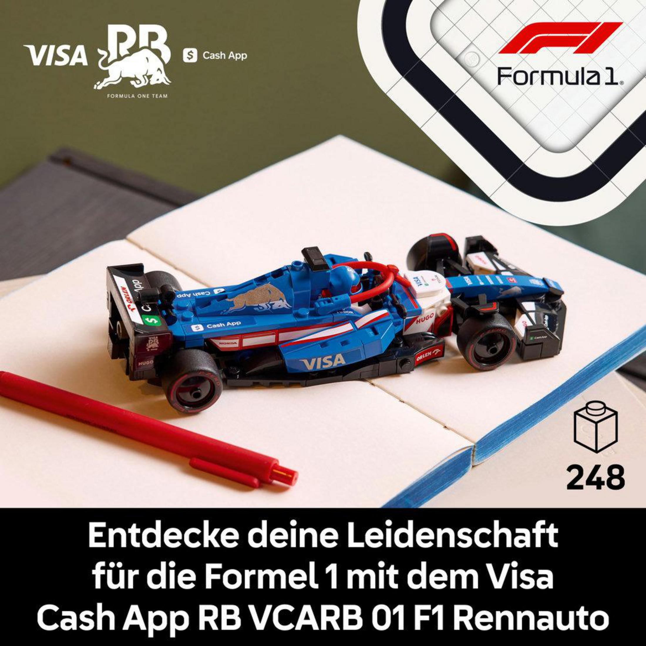 Niebieski samochód Formuły 1 Lego na białej powierzchni. Widoczny jest również czerwony długopis i pudełko Lego.