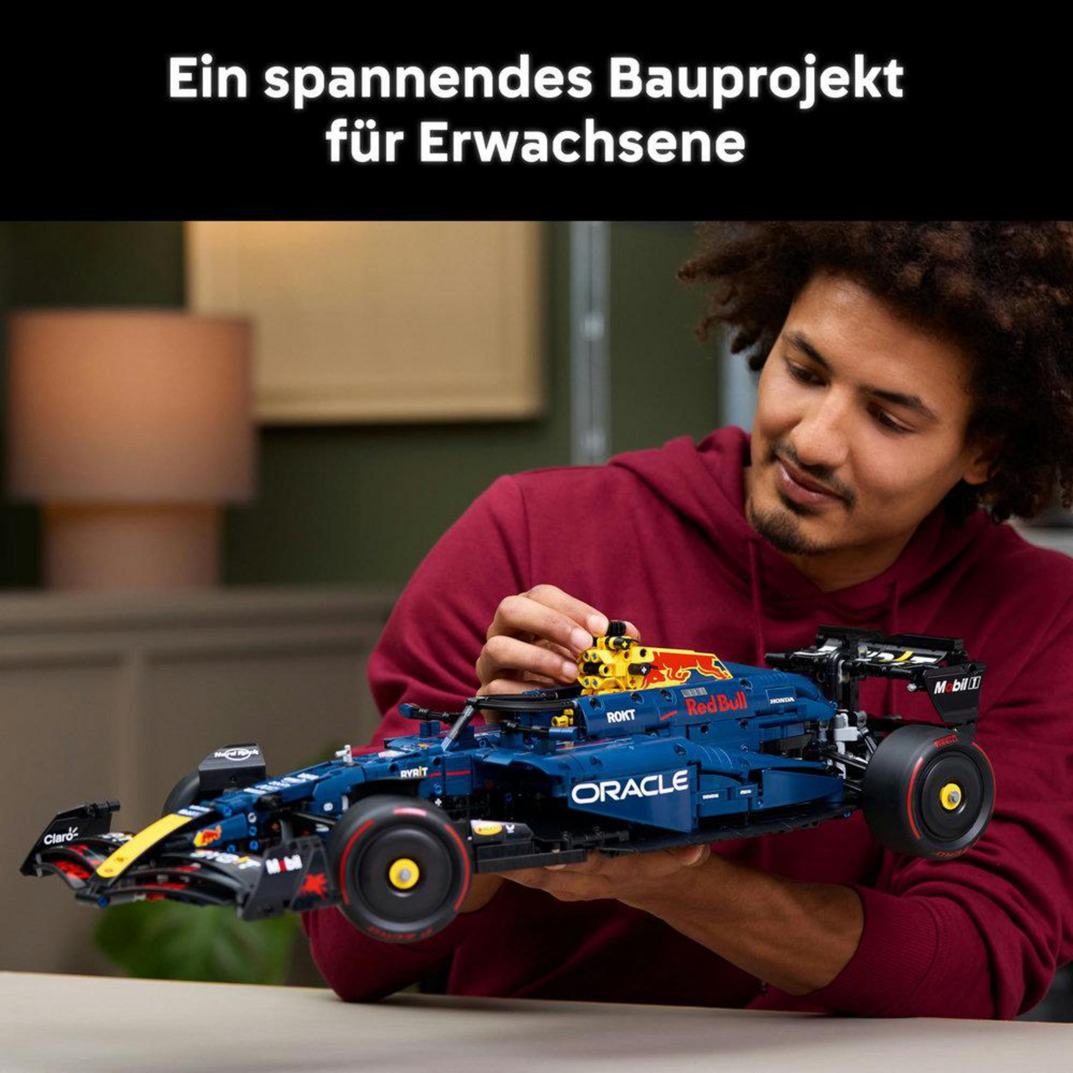 Mężczyzna składający samochód Lego Technic Red Bull Racing F1, z pudełkiem i detalami.