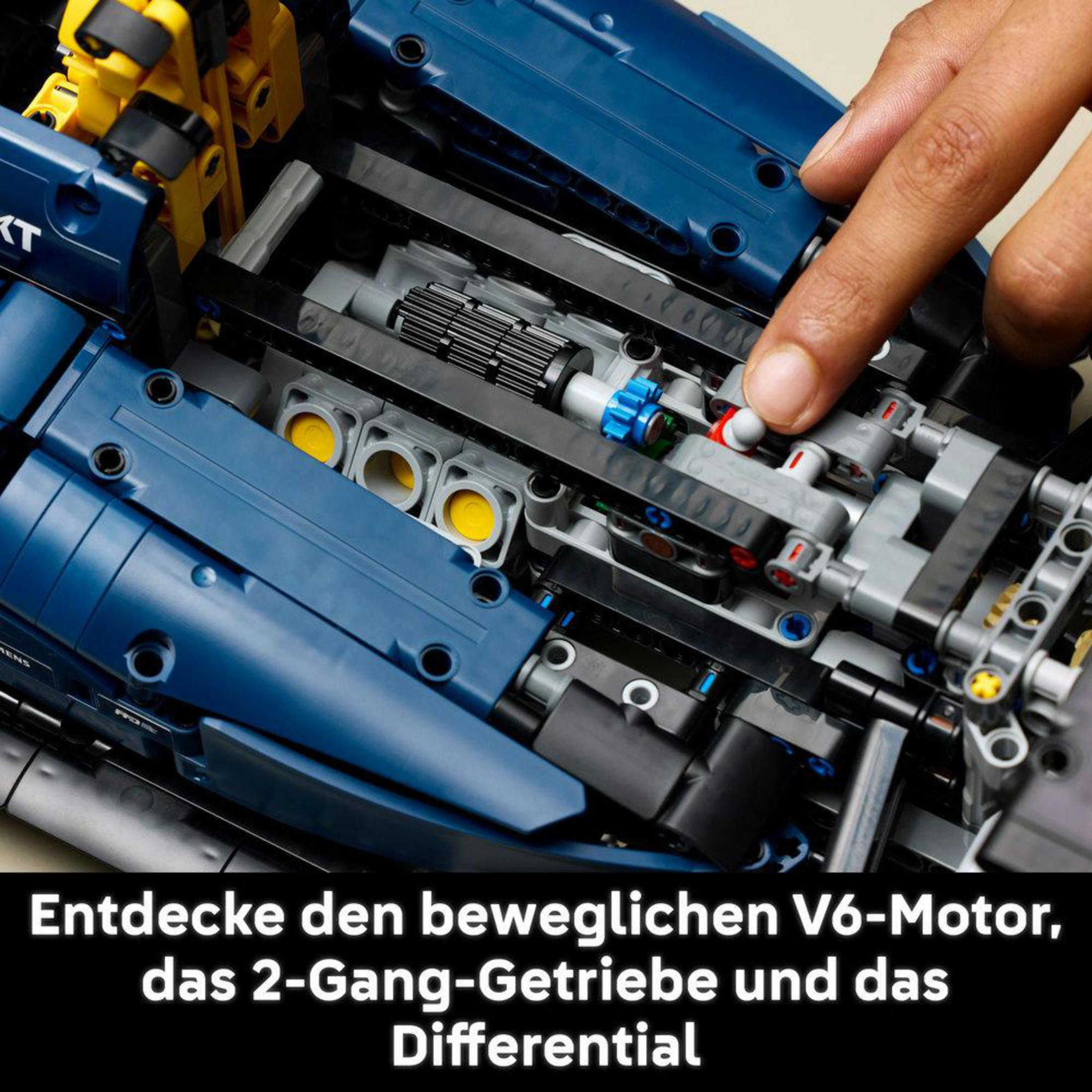 Zbliżenie niebieskiego i czarnego modelu LEGO Technic z ręką wskazującą na silnik.