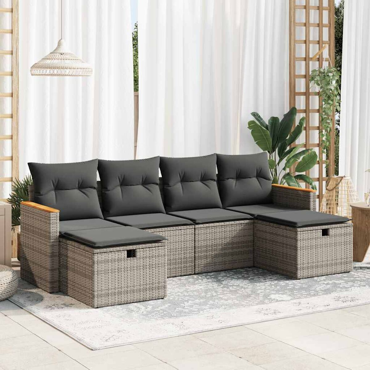 Graues Korbsessel-Sofa mit dunkelgrauen Kissen auf einem hellgrauen Teppich, mit weißem Hintergrund.
