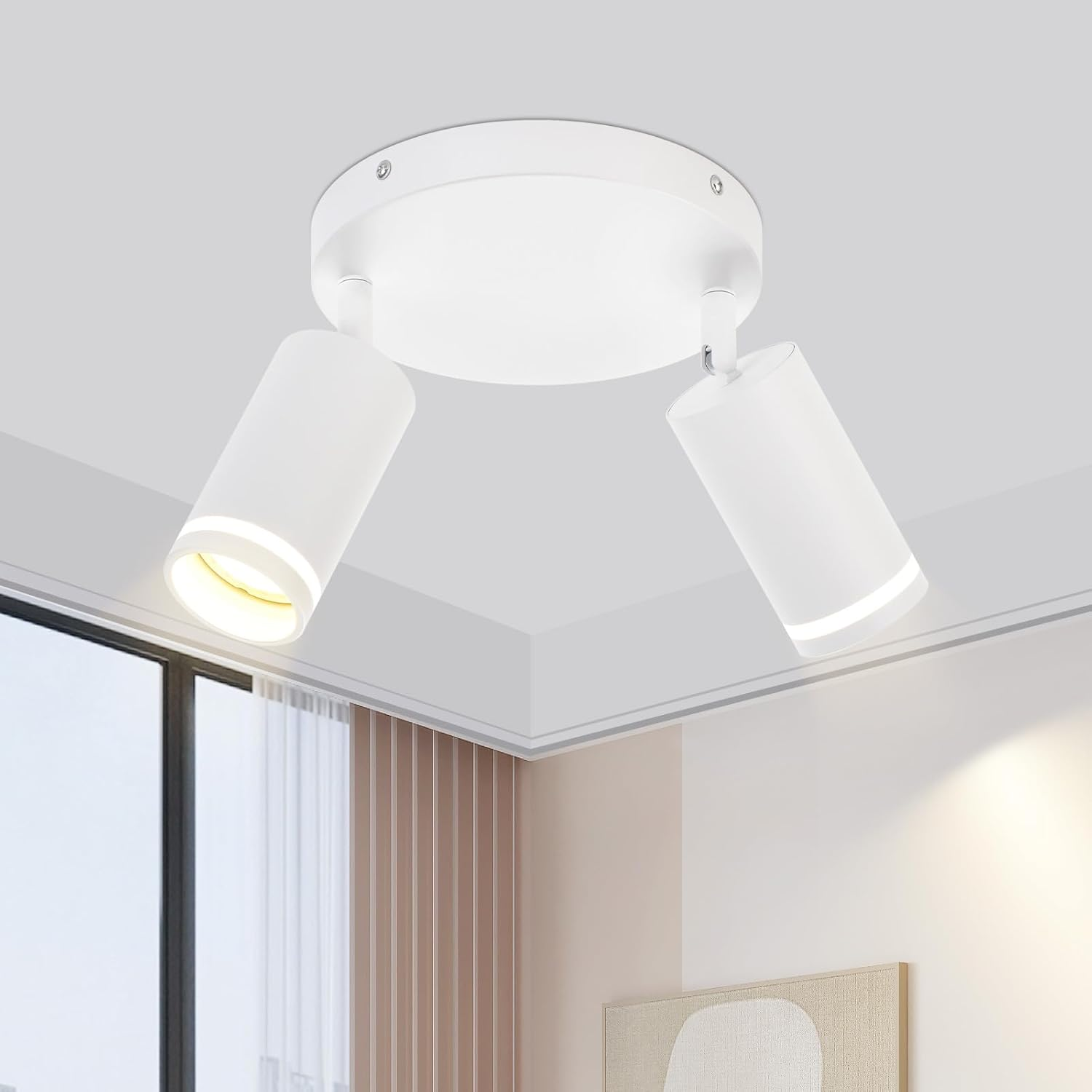 Biała lampa sufitowa z dwoma regulowanymi reflektorami. Jest zainstalowana w rogu pomieszczenia.