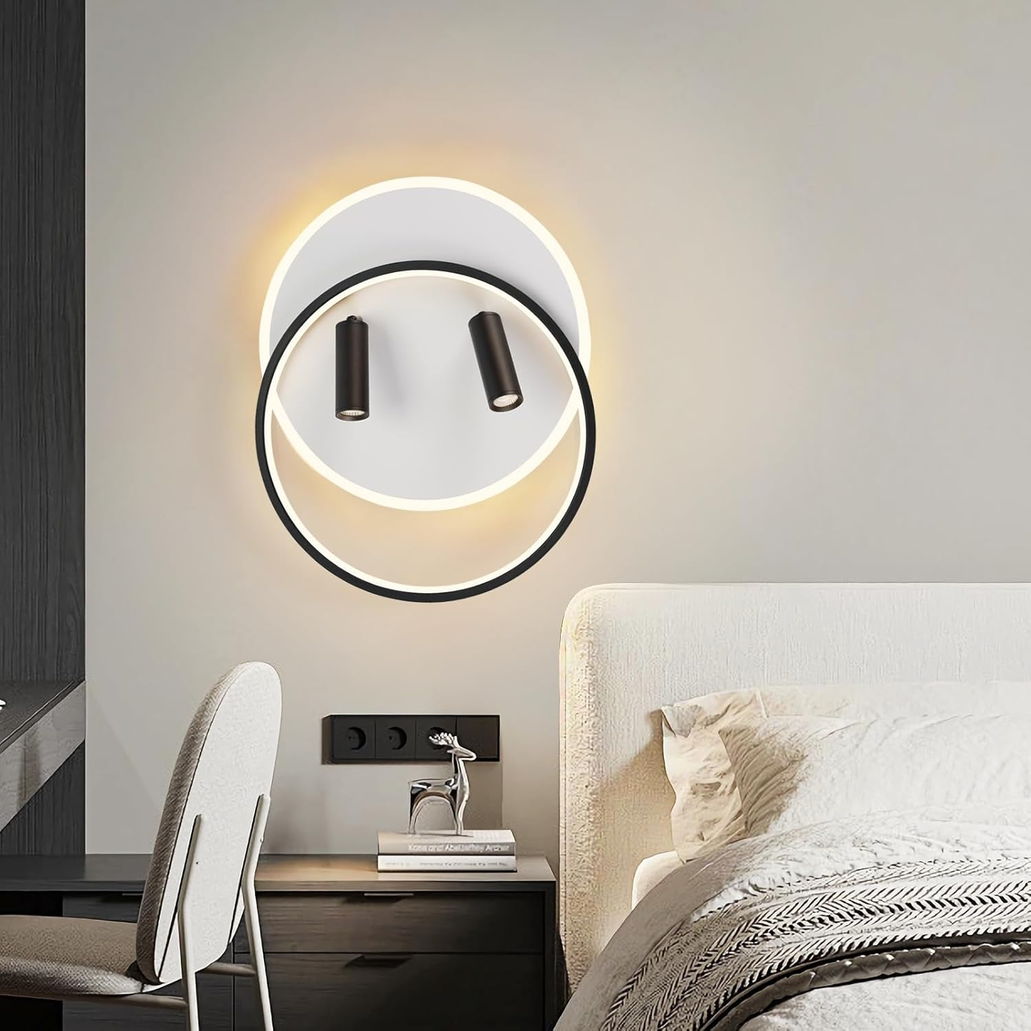 Luce da parete con un design circolare in bianco e nero e due faretti neri. La luce è sopra un letto.