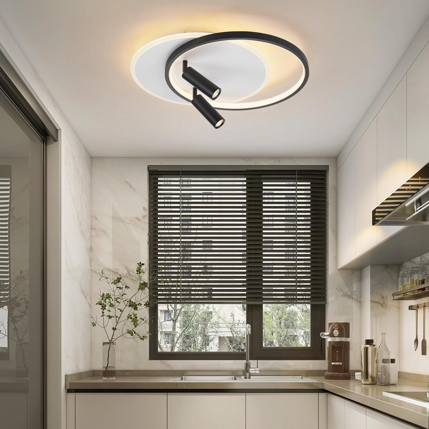 Cucina con una lampada da soffitto con design circolare in bianco e nero e due faretti neri. Una finestra è visibile.