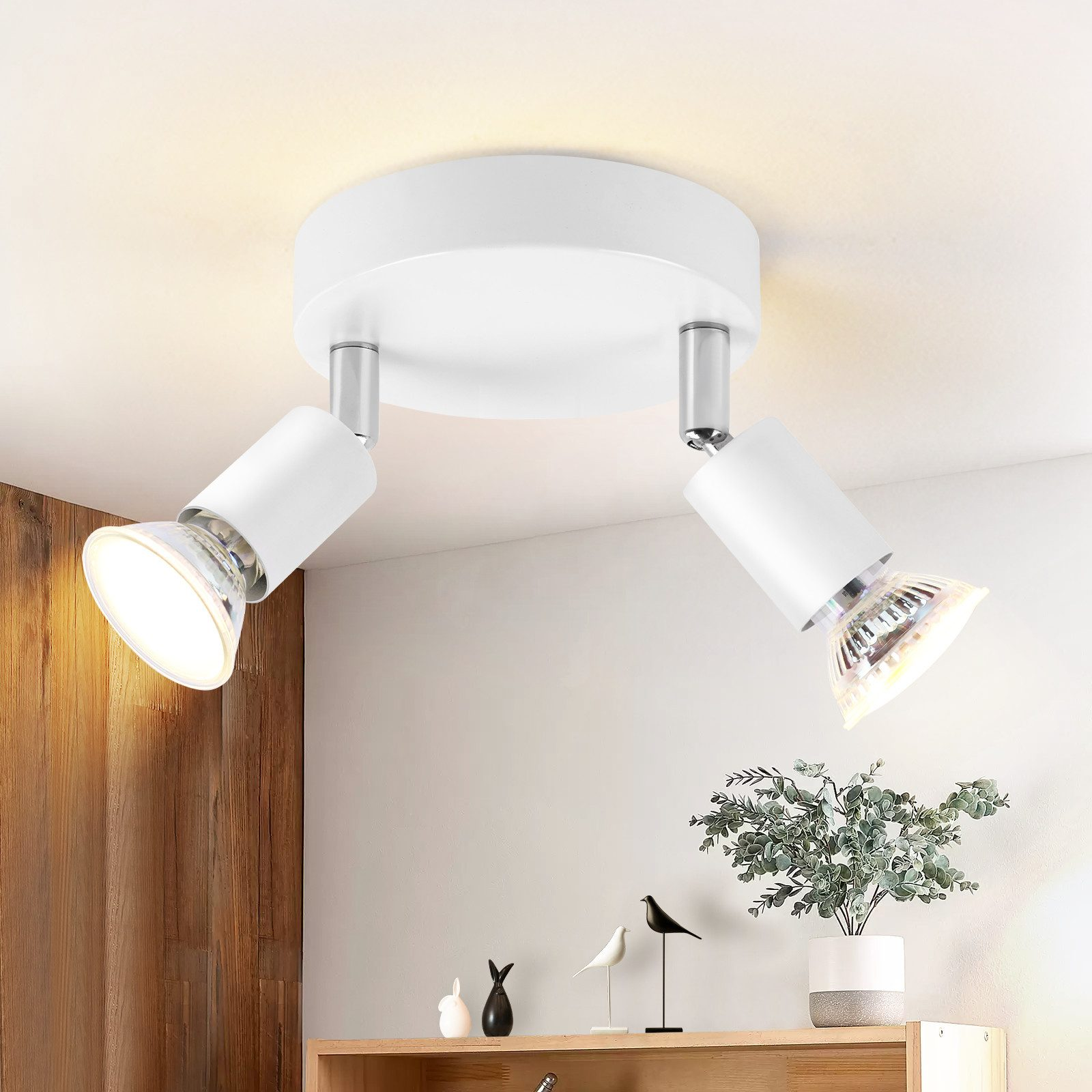 Lampada da soffitto bianca con due faretti orientabili. Lo sfondo è un soffitto bianco.