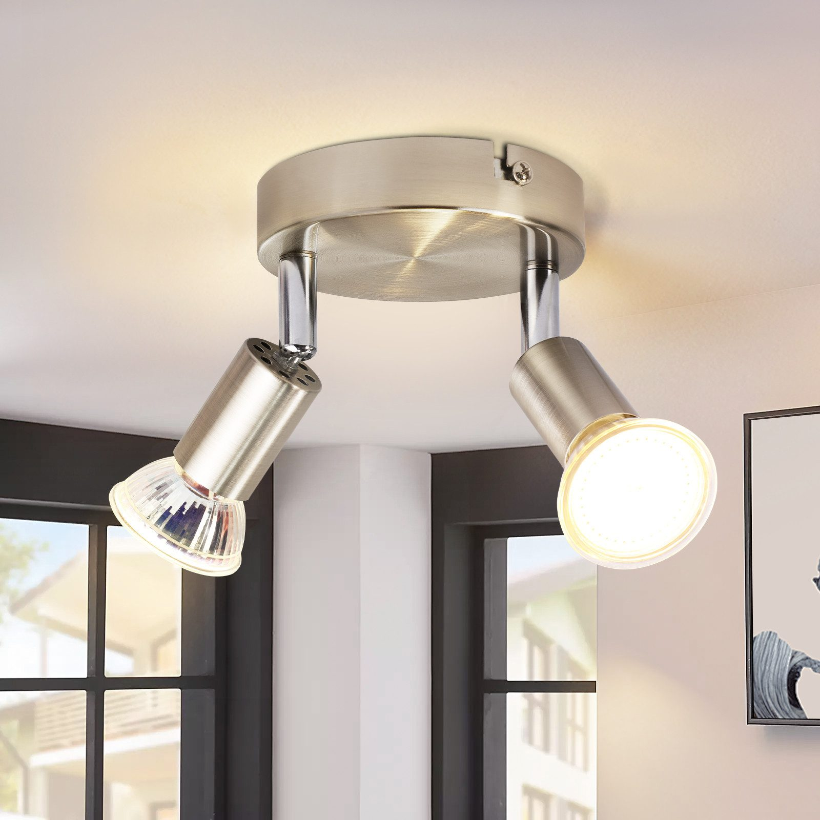 Due faretti argentati su un soffitto, con una copertura in vetro trasparente.