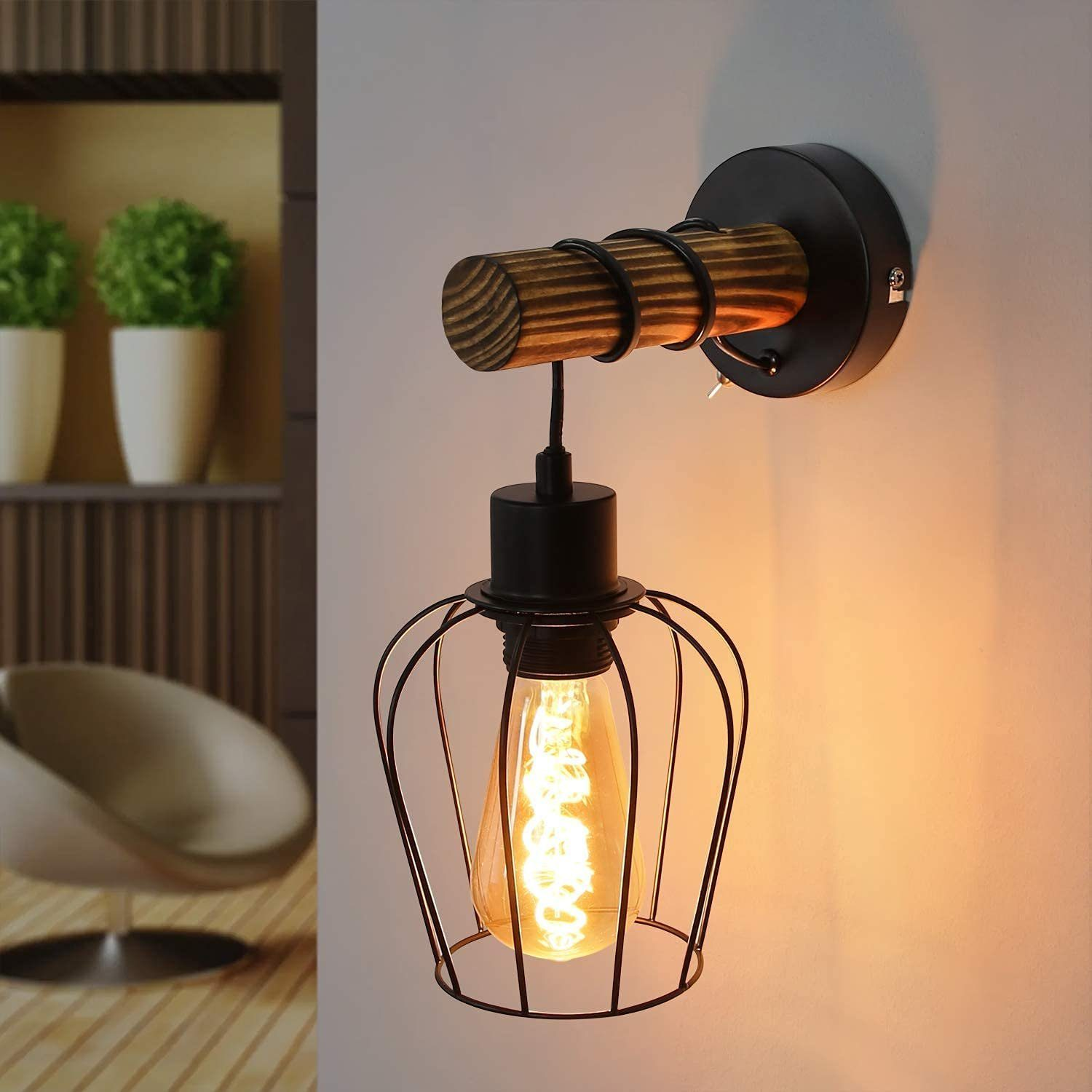 Un'applique da parete con una trave di legno e una gabbia nera attorno a una lampadina.