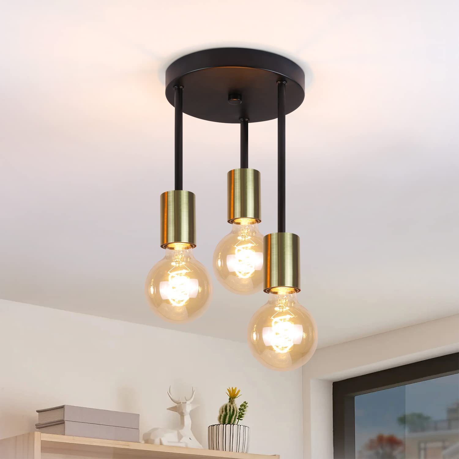 Lampada da soffitto con tre lampadine. Le lampadine sono rotonde e l'apparecchio ha una base nera.