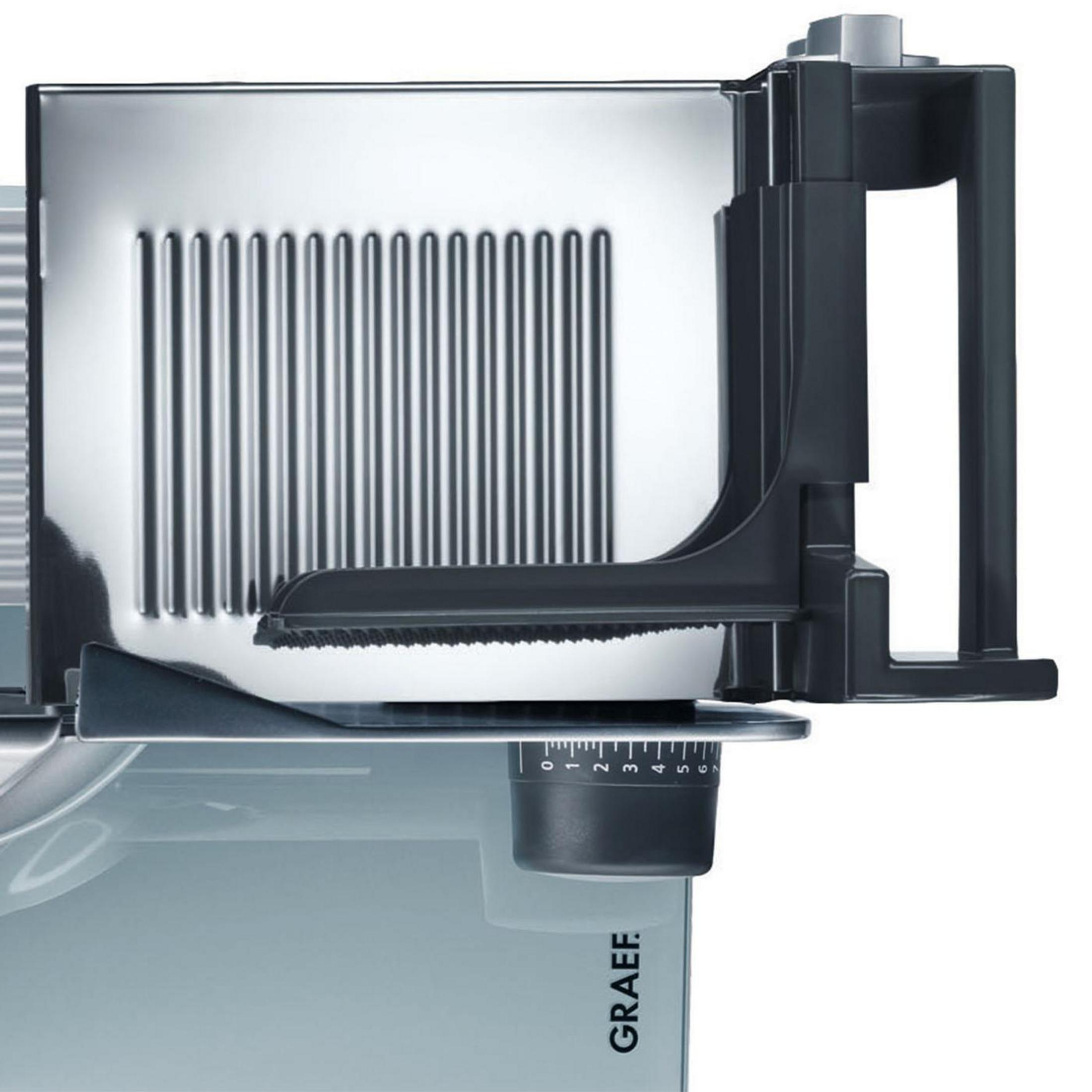 Zbliżenie srebrno-czarnej krajalnicy do mięsa. Widoczne ostrze, uchwyt i pokrętło regulacji.