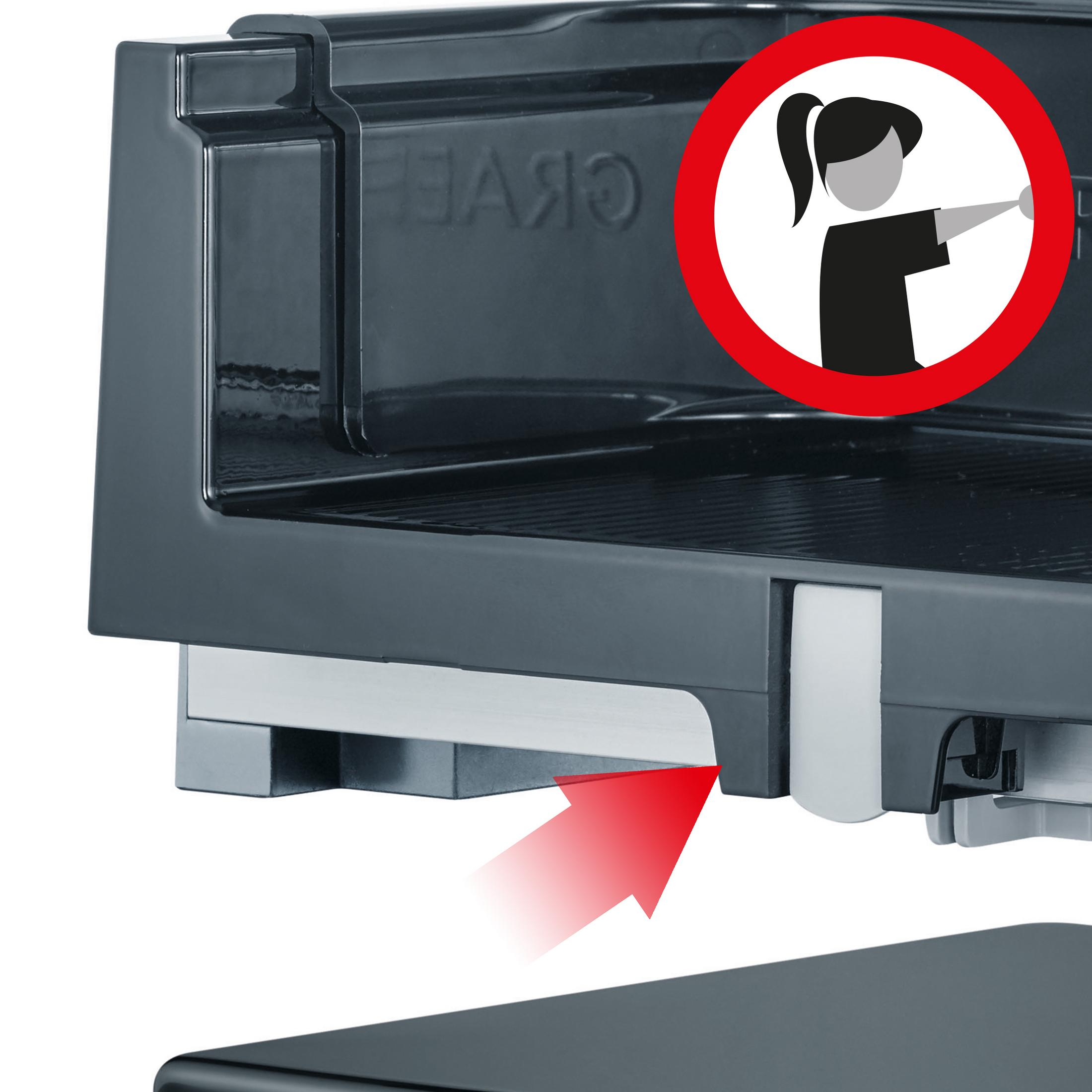 Zbliżenie krajalnicy z czerwoną strzałką wskazującą mechanizm zwalniający. Białe tło.