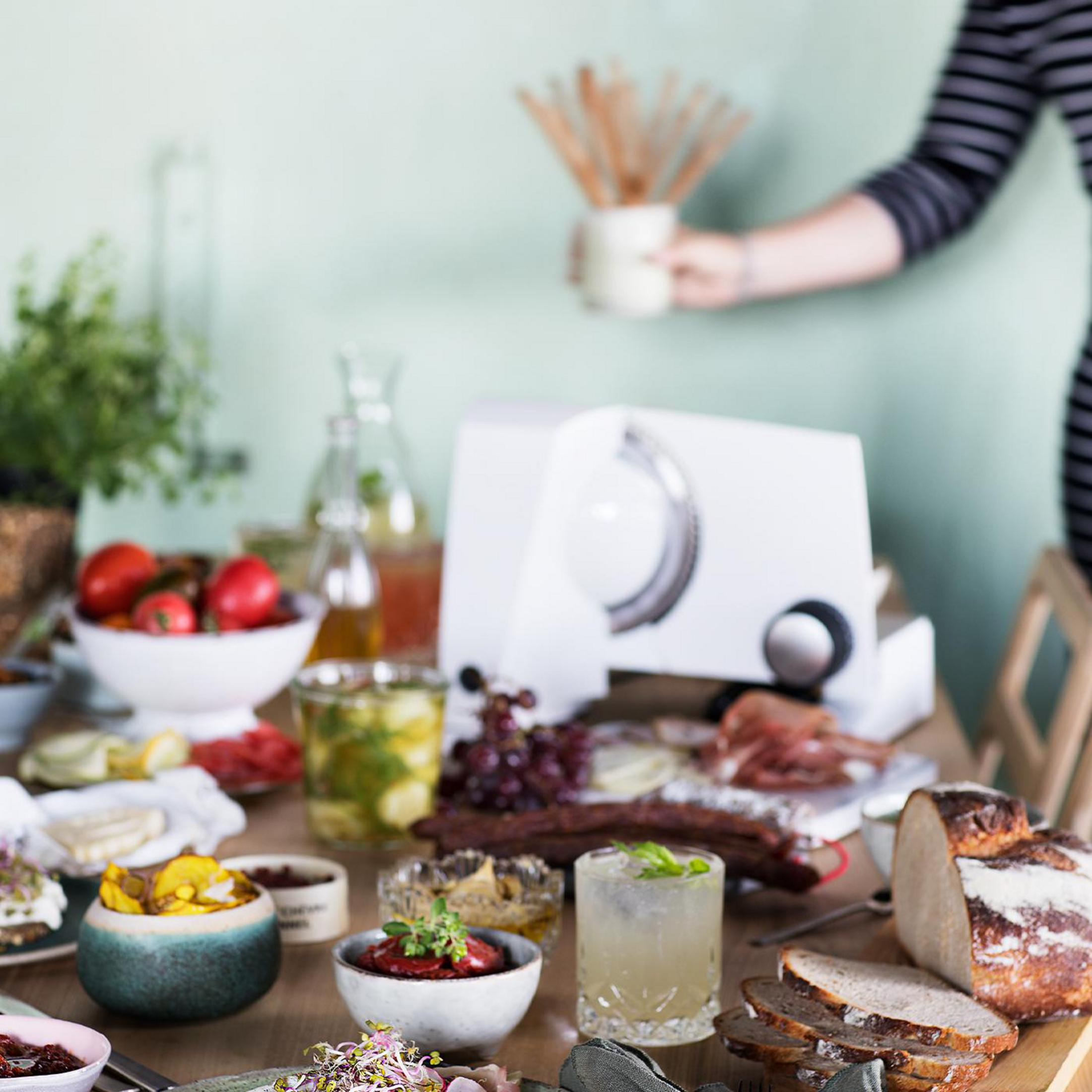 Stół z jedzeniem i białą krajalnicą do żywności.
