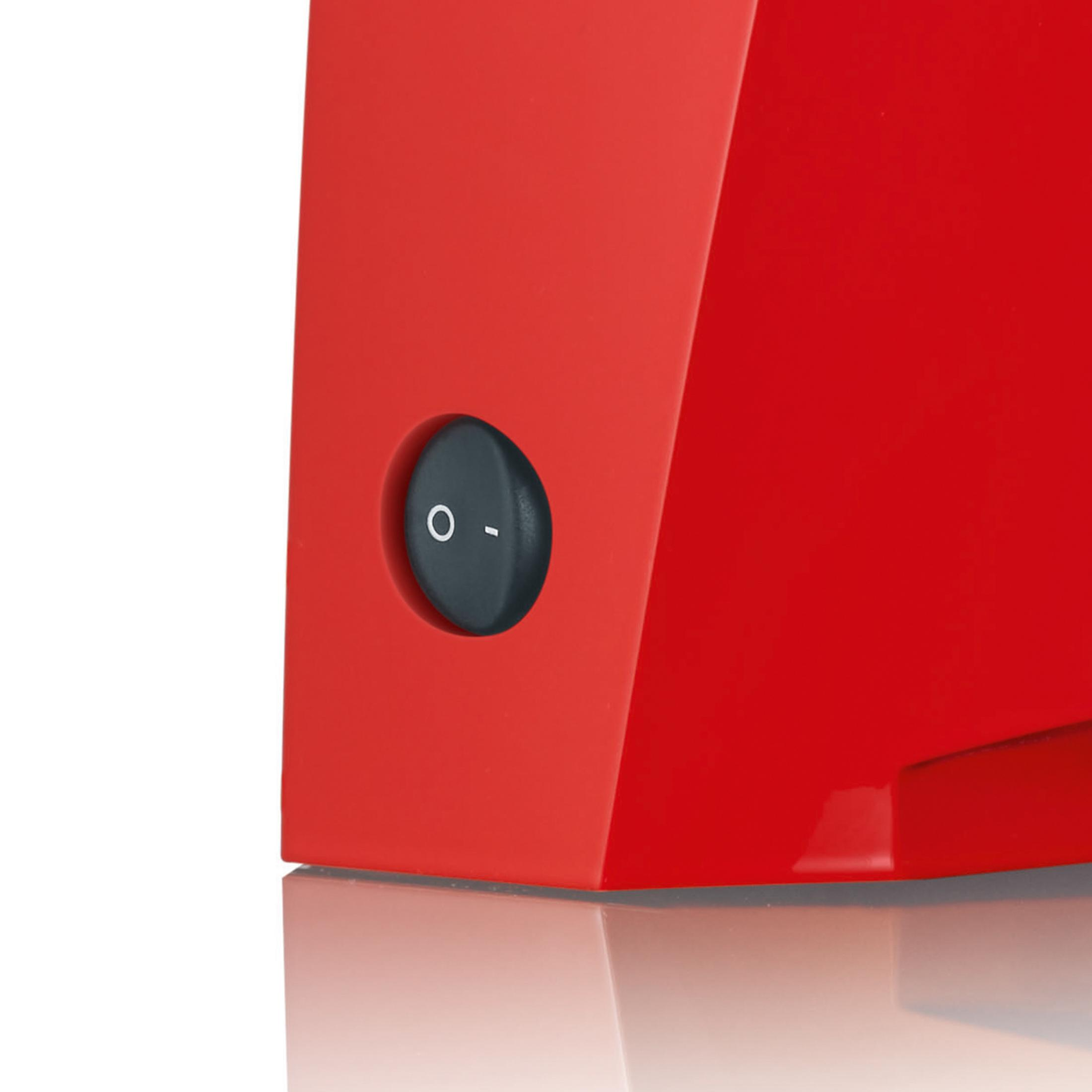 Czerwone urządzenie z czarnym przyciskiem włącz/wyłącz.