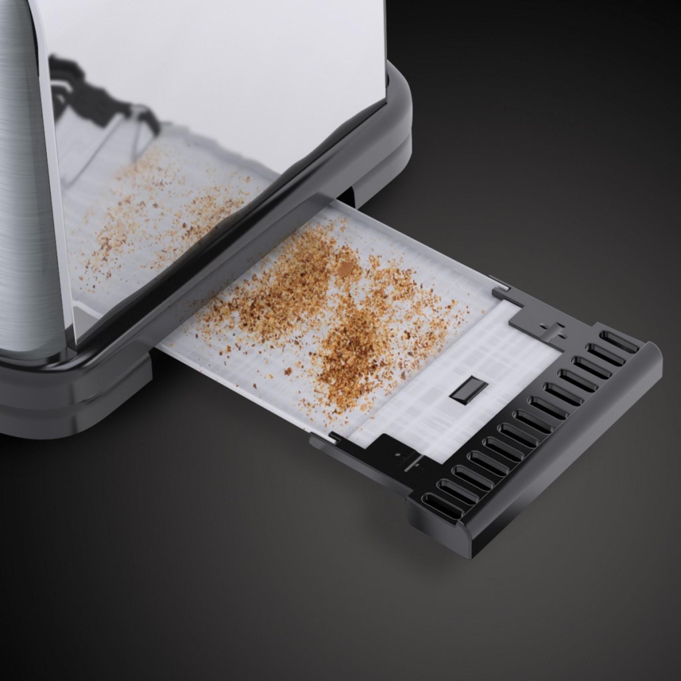 Zbliżenie tacki na okruchy tostera, wysuniętej, z okruchami w środku na czarnym tle.