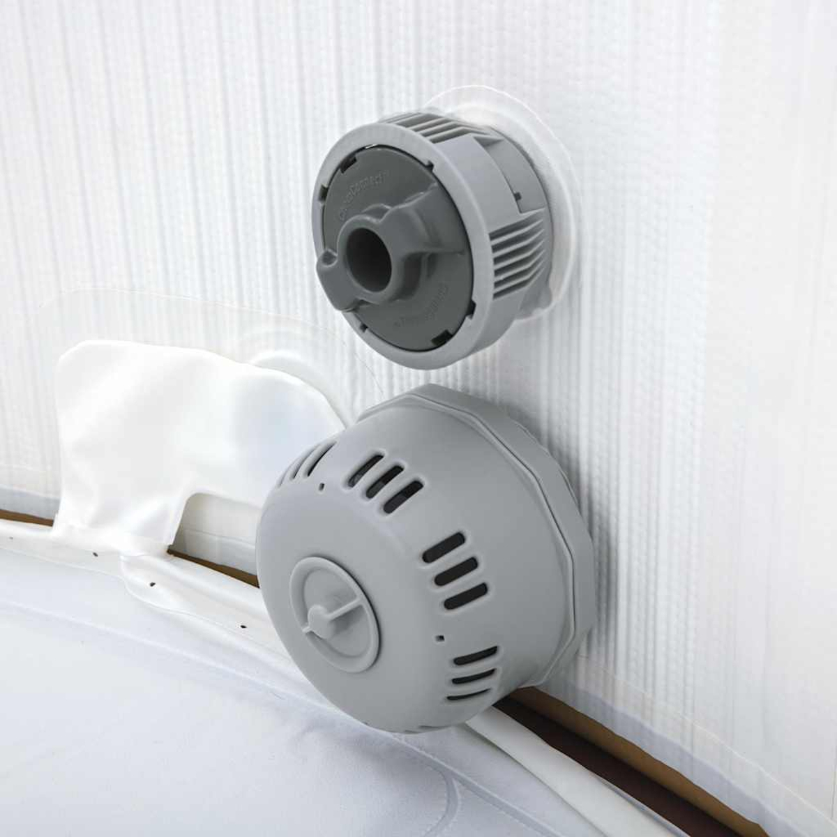 Zwei graue Poolfilter an der weißen Wand, mit einem weißen Tuch.