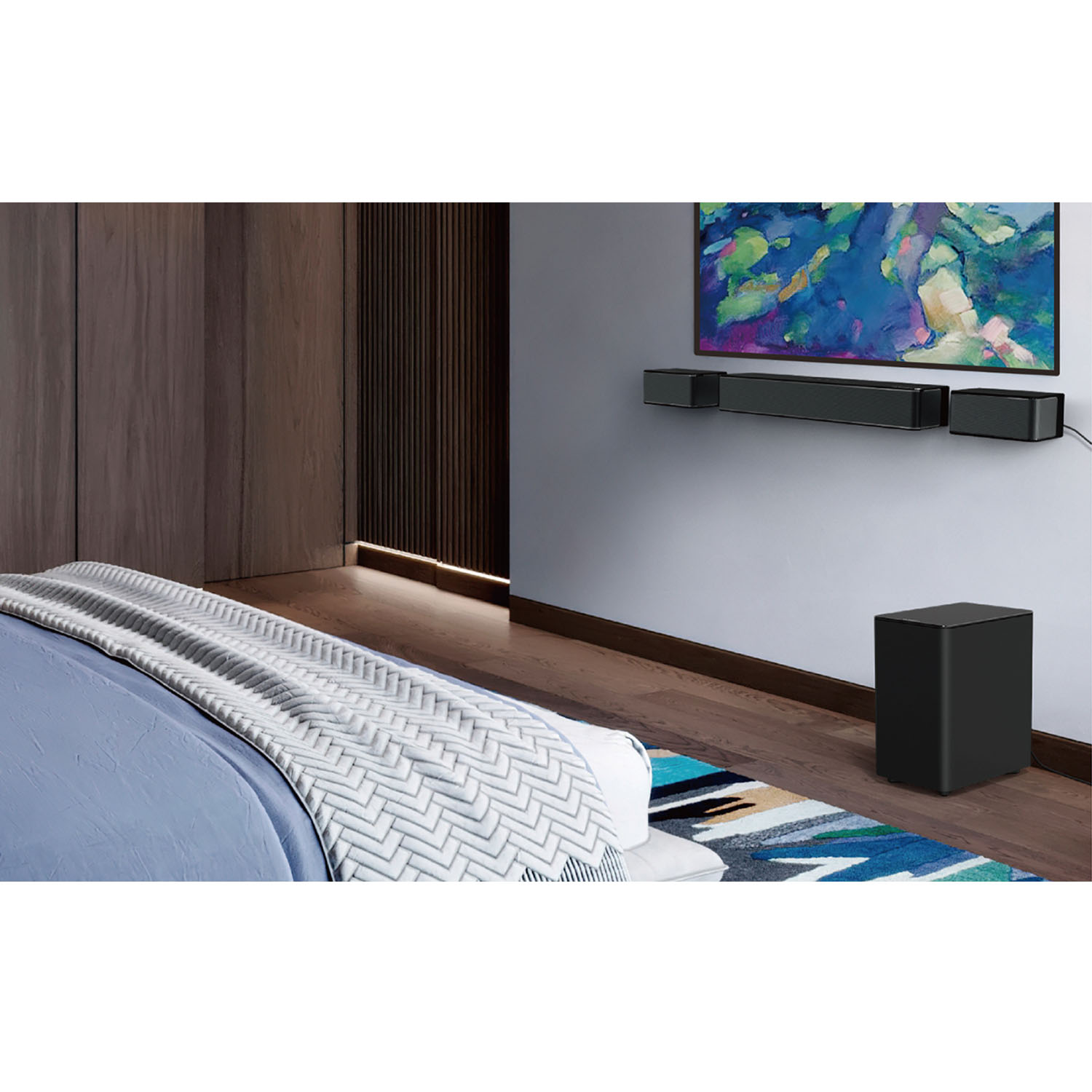Scène de chambre avec TV, barre de son et caisson de basses au mur, et un lit avec une couverture.