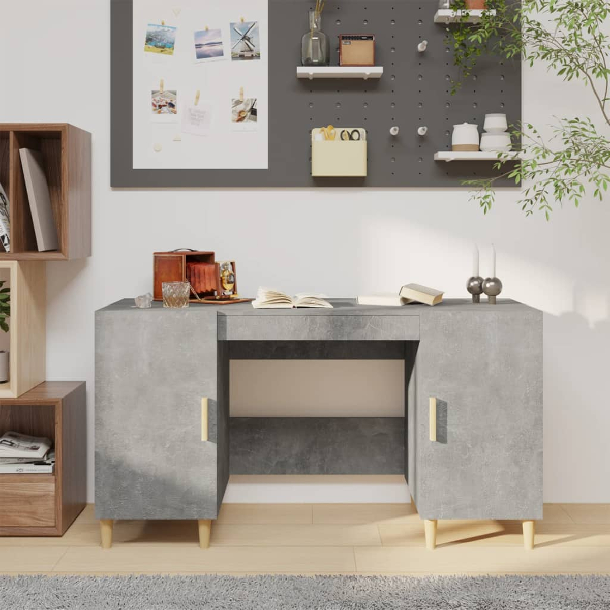 Ein Betontisch mit Holzbeinen, eine Pinnwand und Dekoration wie Bücher und eine Kamera.