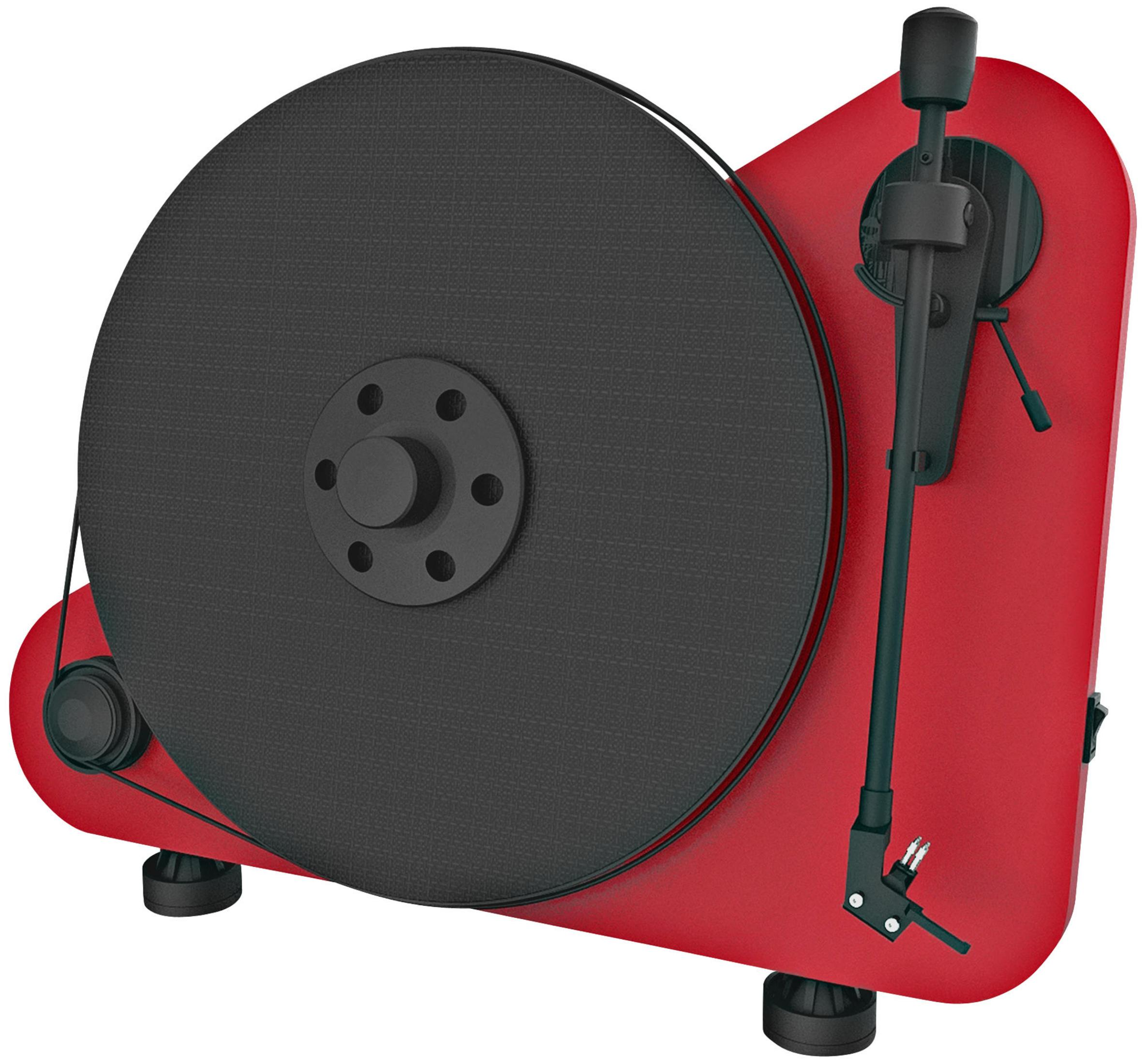 A red turntable with a black record, tonearm, and other components, positioned on a white surface.