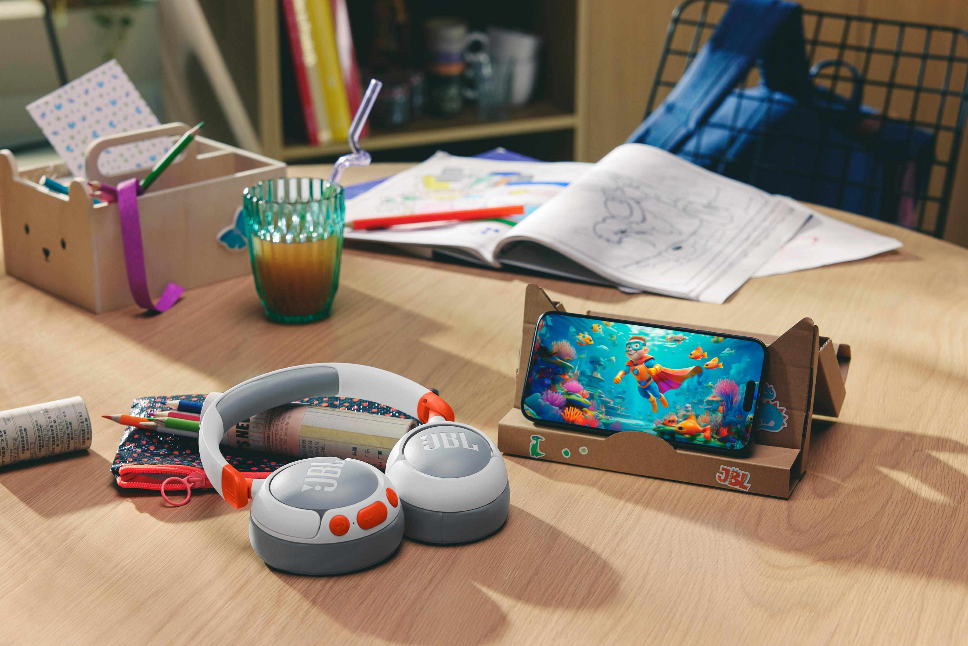 Biurko ze słuchawkami, telefonem z kreskówką i przyborami szkolnymi.