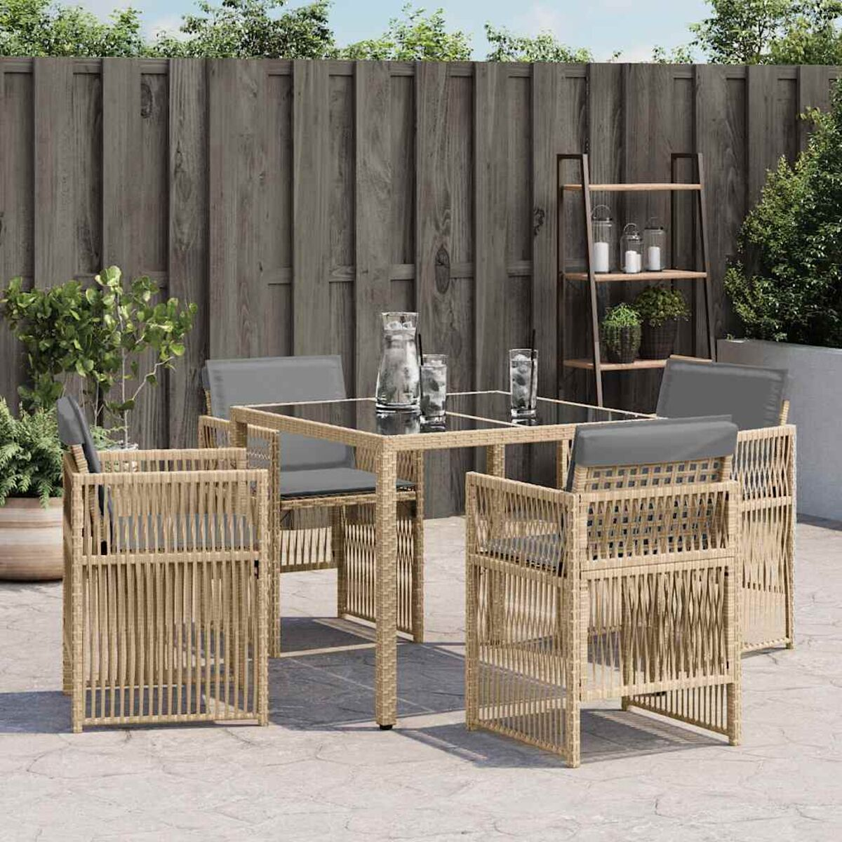 Essgruppe im Freien. Rattanstühle und Tisch. Klares Glas auf dem Tisch. Sonniger Tag.