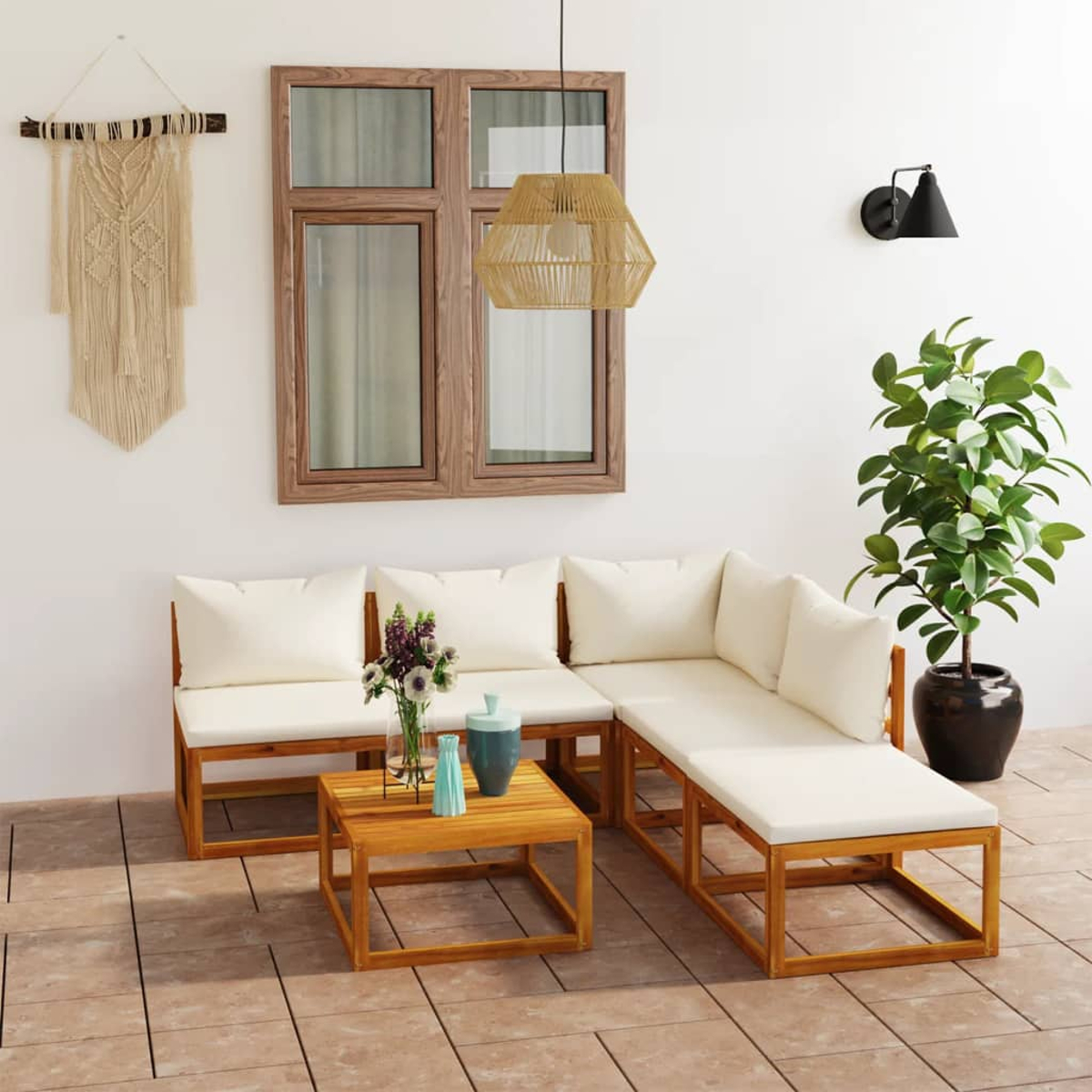 Wohnzimmer-Setup im Freien mit Sofa, Couchtisch und Dekorationen. Holzmöbel, weiße Kissen und Pflanzen.