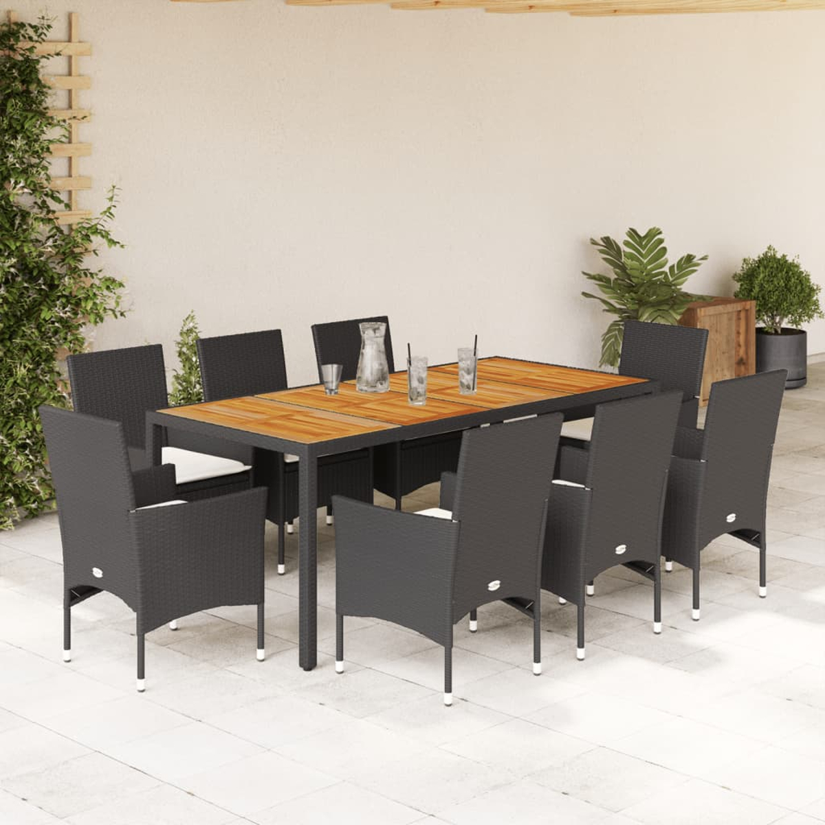 Essgruppe im Freien: Tisch mit Holzplatte, acht schwarze Korbstühle, weiße Kissen.