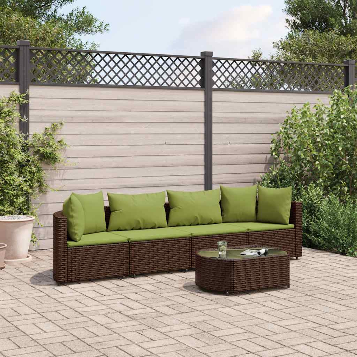 Braunes Korbmöbel mit grünen Kissen und Tisch im Garten.