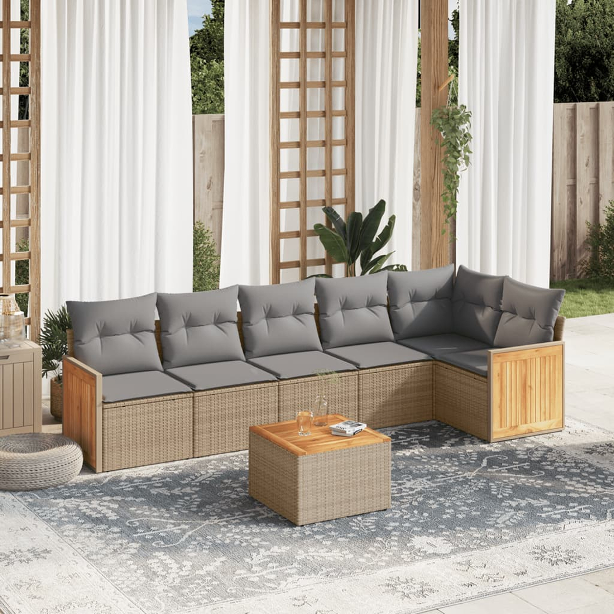 Ein geflochtenes Outdoor-Ecksofa mit grauen Kissen, einem Teppich und einem Holztisch.