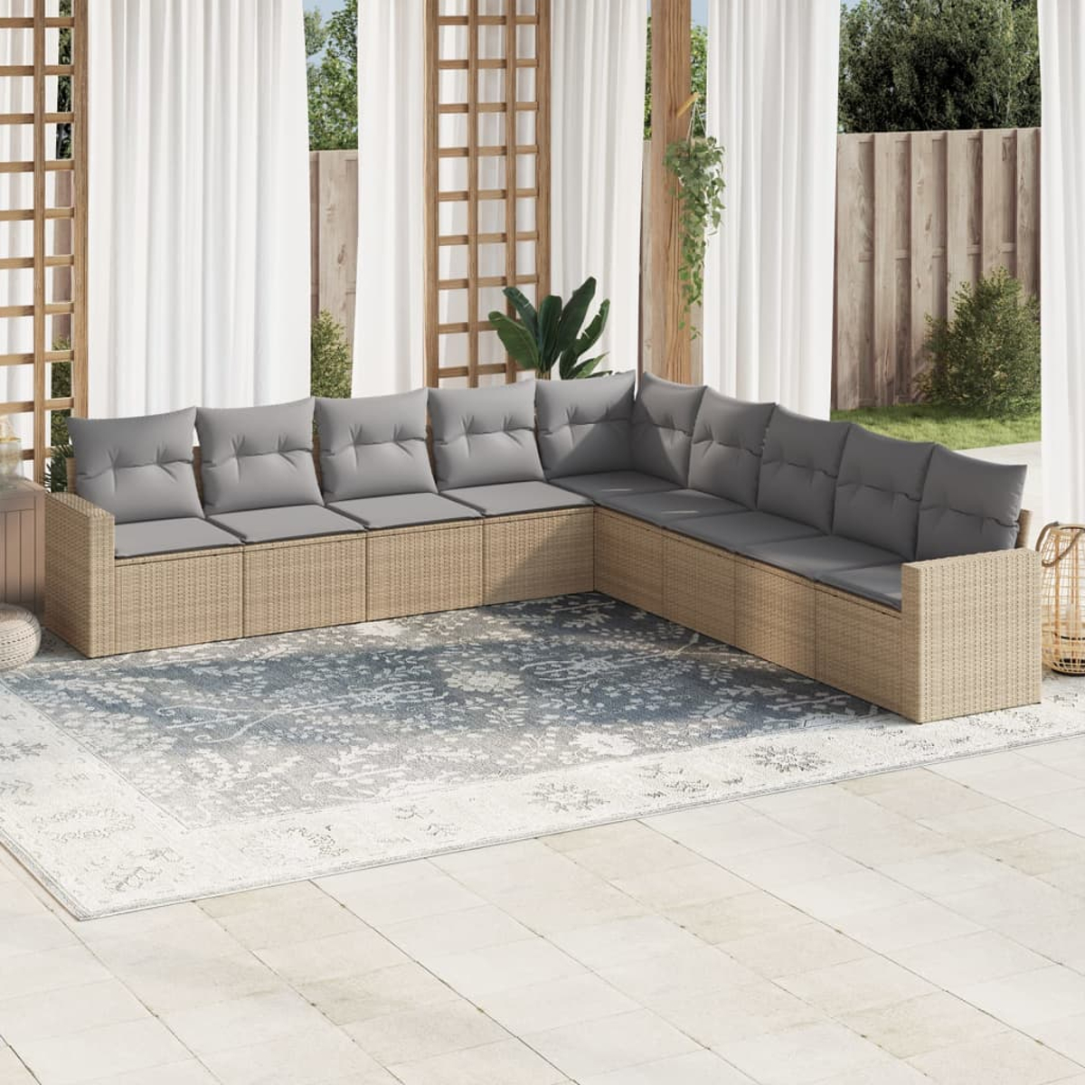 Beiges Outdoor-Ecksofa aus Korbgeflecht mit grauen Kissen. Teppich und Vorhänge im Hintergrund.