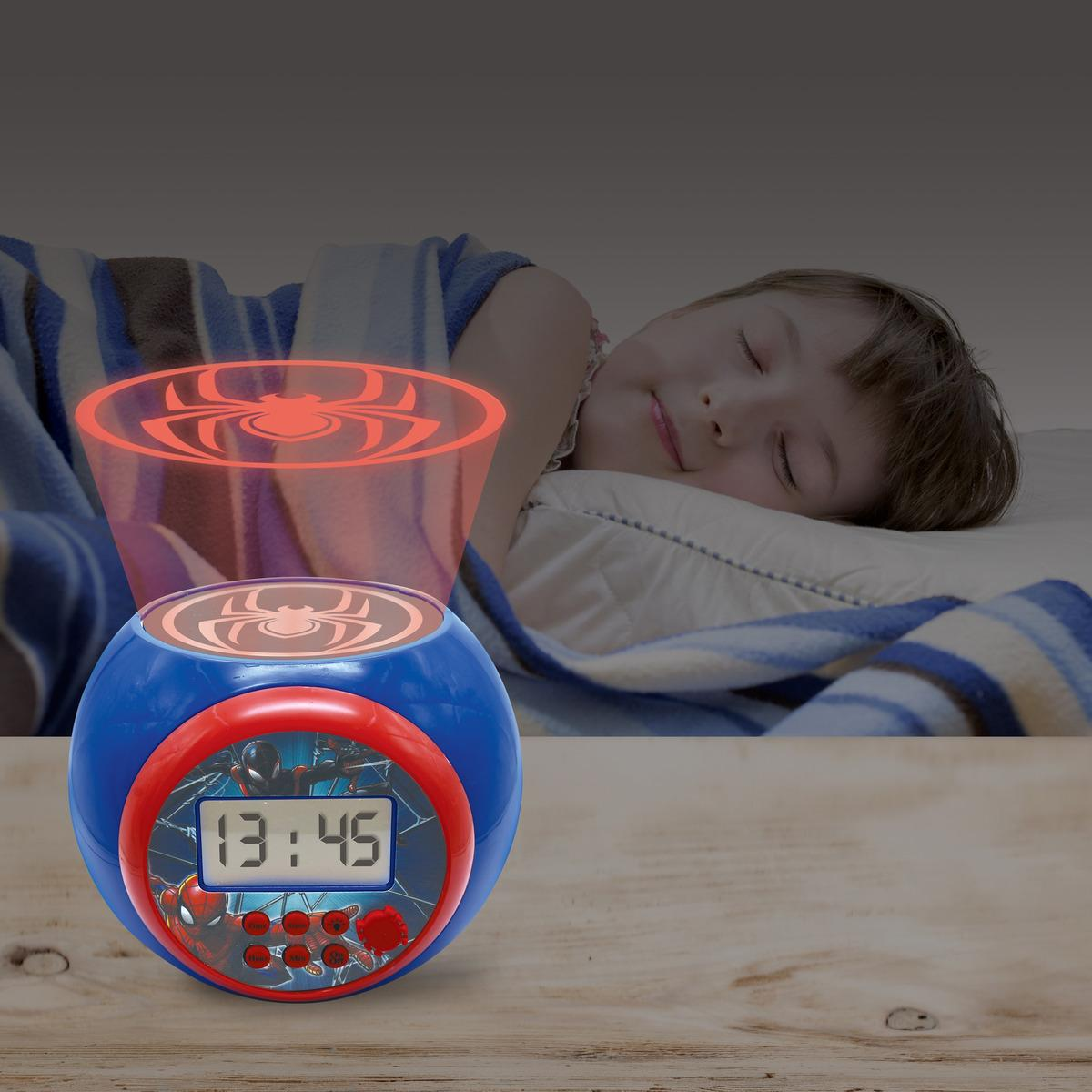 Un niño duerme cerca de un reloj de Spider-Man que proyecta el logotipo de Spider-Man.
