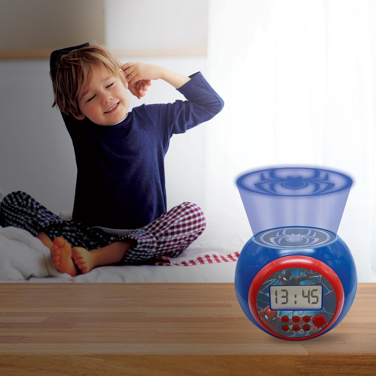 Un niño pequeño se despierta y se estira cerca de un despertador de Spider-Man sobre una mesa.