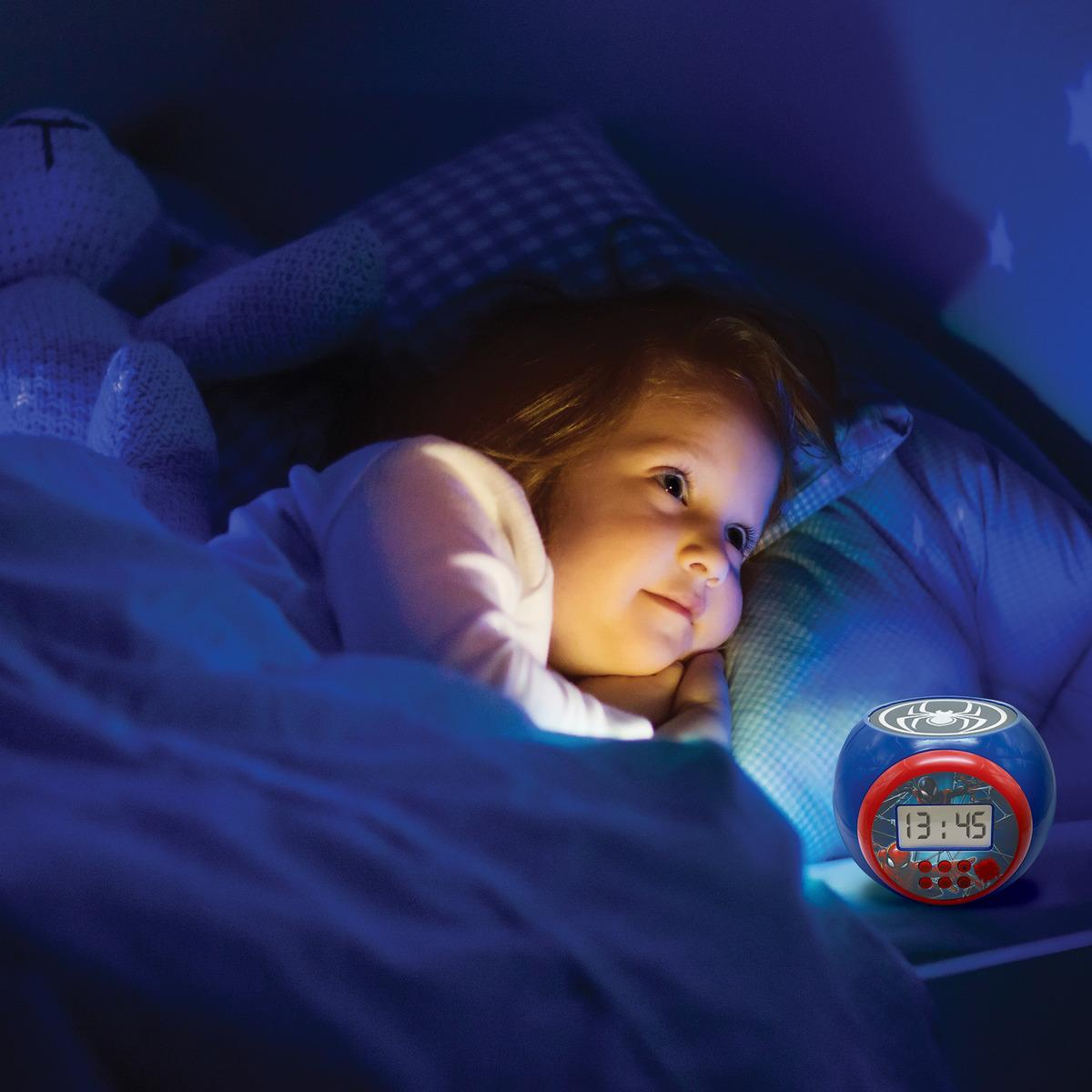 Niña en la cama mirando un reloj azul con la hora mostrada.